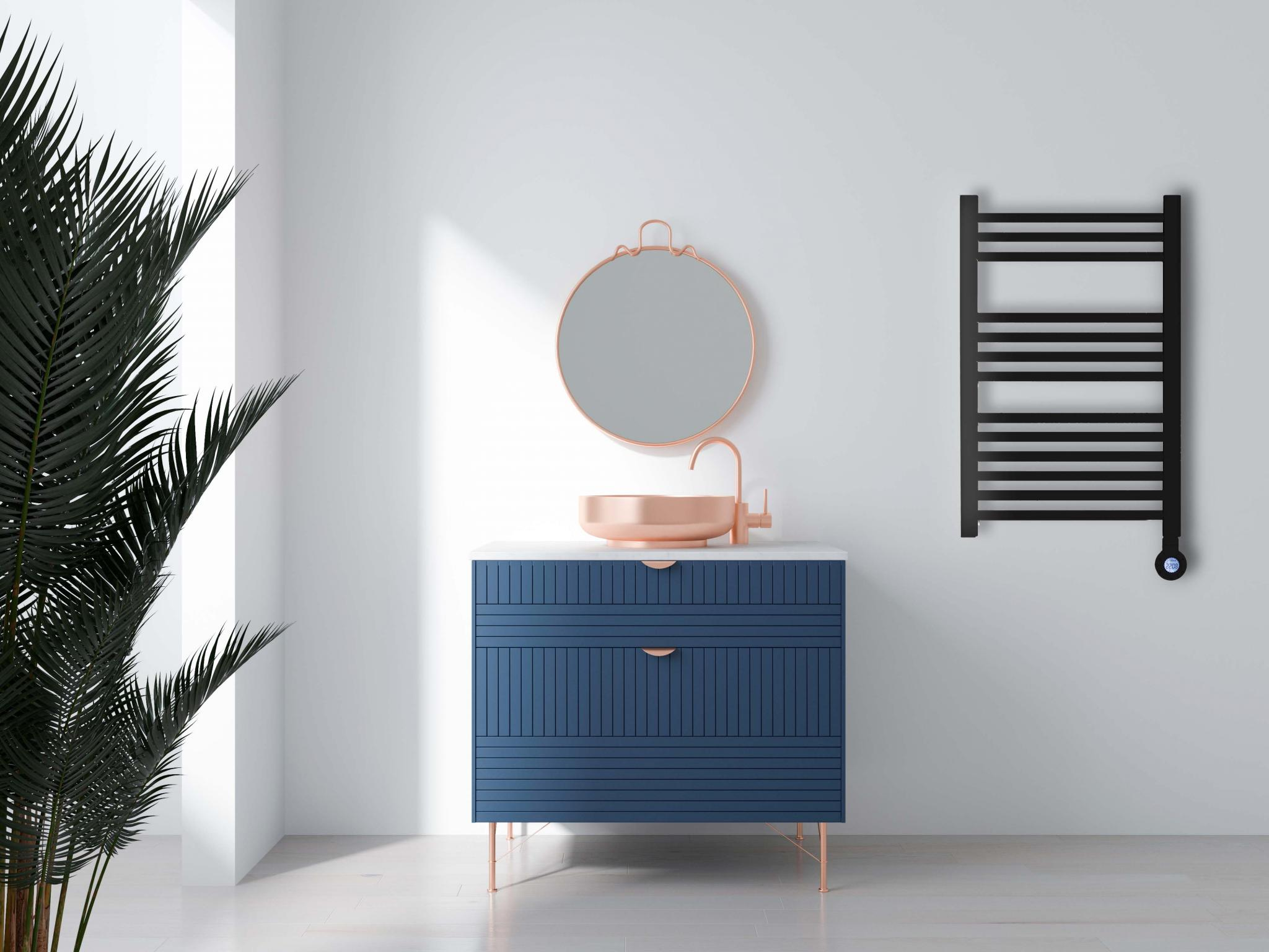 Escena de baño con tocador, espejo y calentador de toallas negro en pared blanca.
