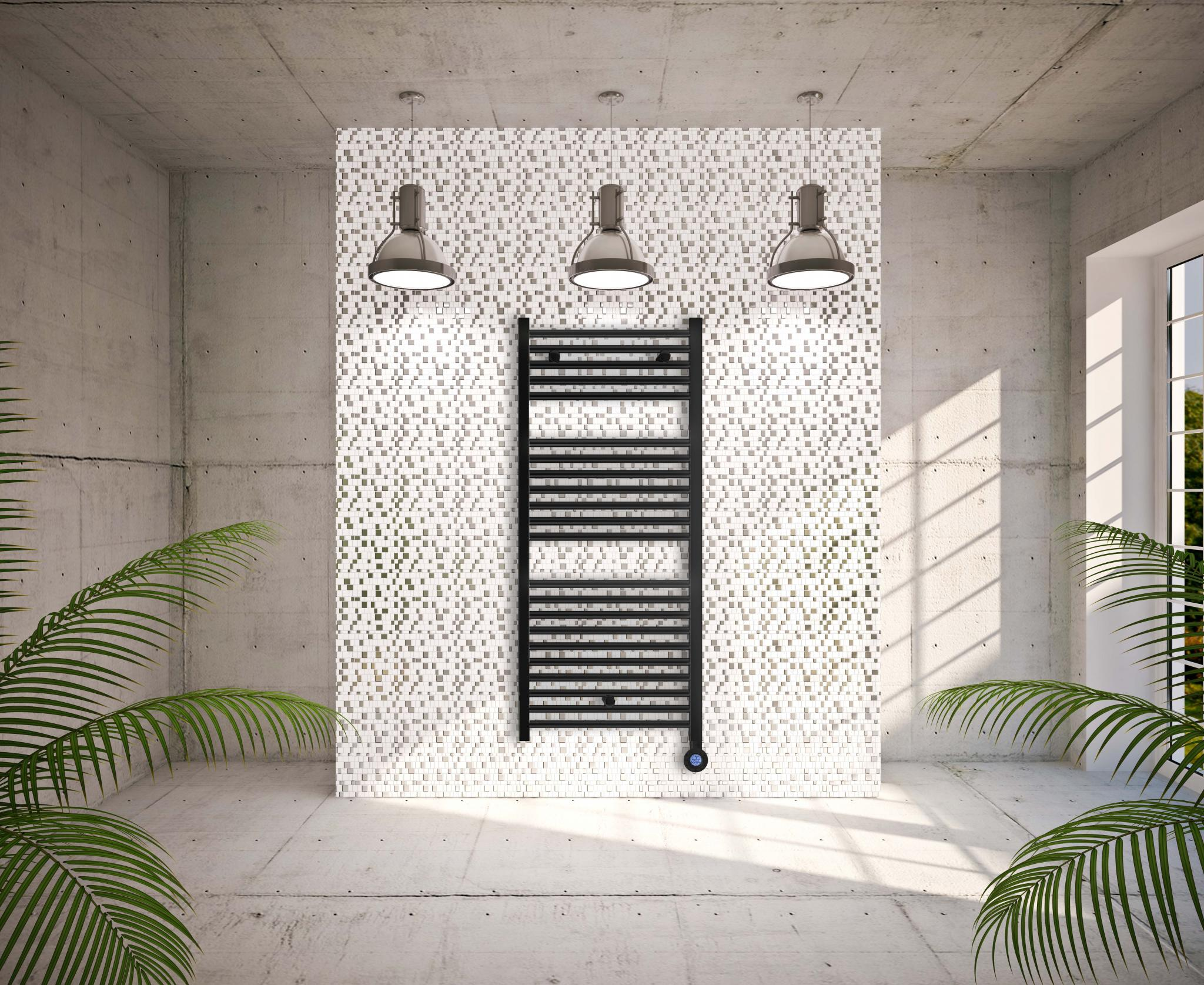 Escena de baño moderno con un toallero negro en una pared alicatada. Tres luces cuelgan encima.