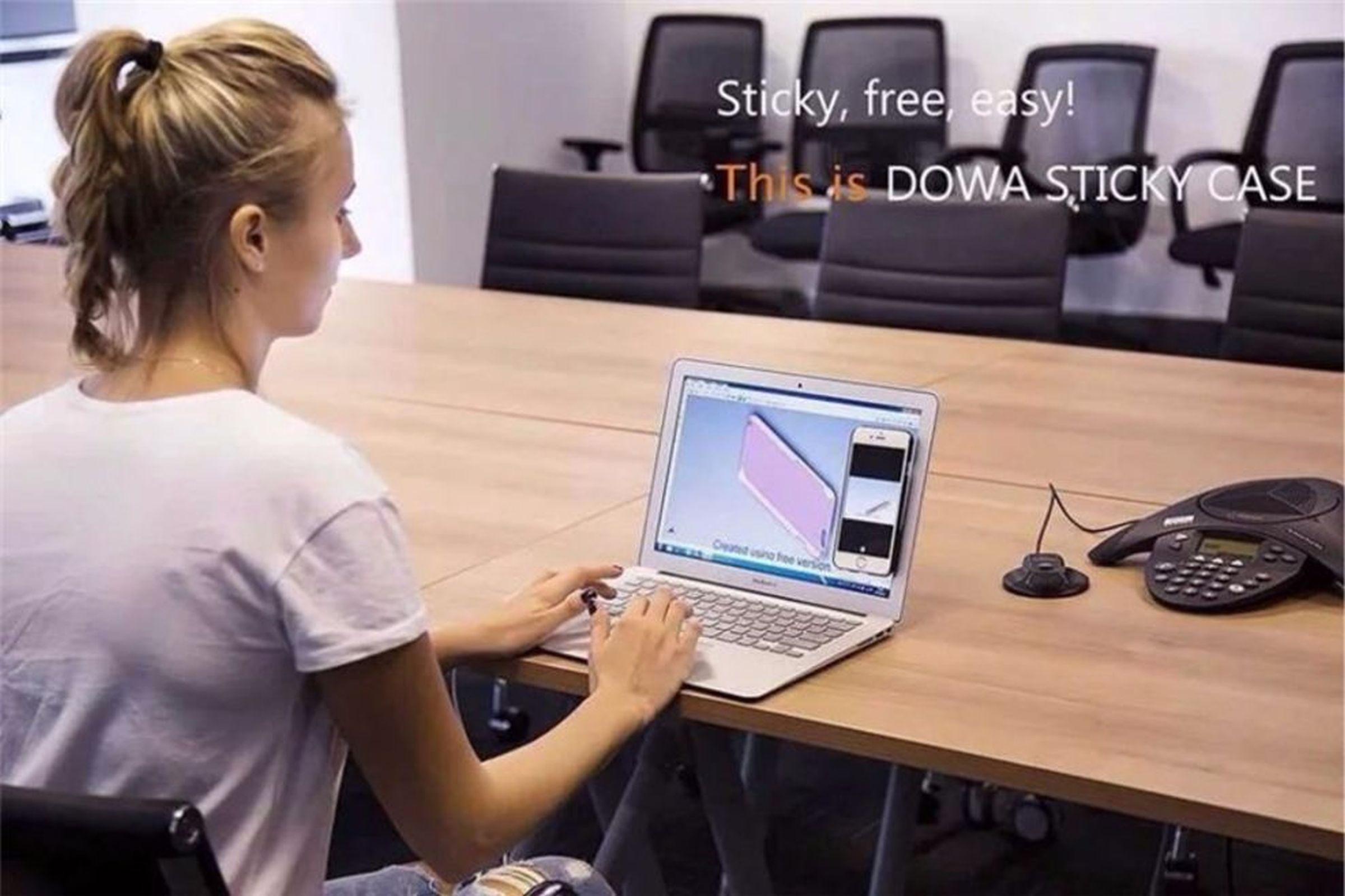 Eine Frau an einem Tisch mit einem Laptop. Der Bildschirm zeigt ein Handyhüllen-Design.