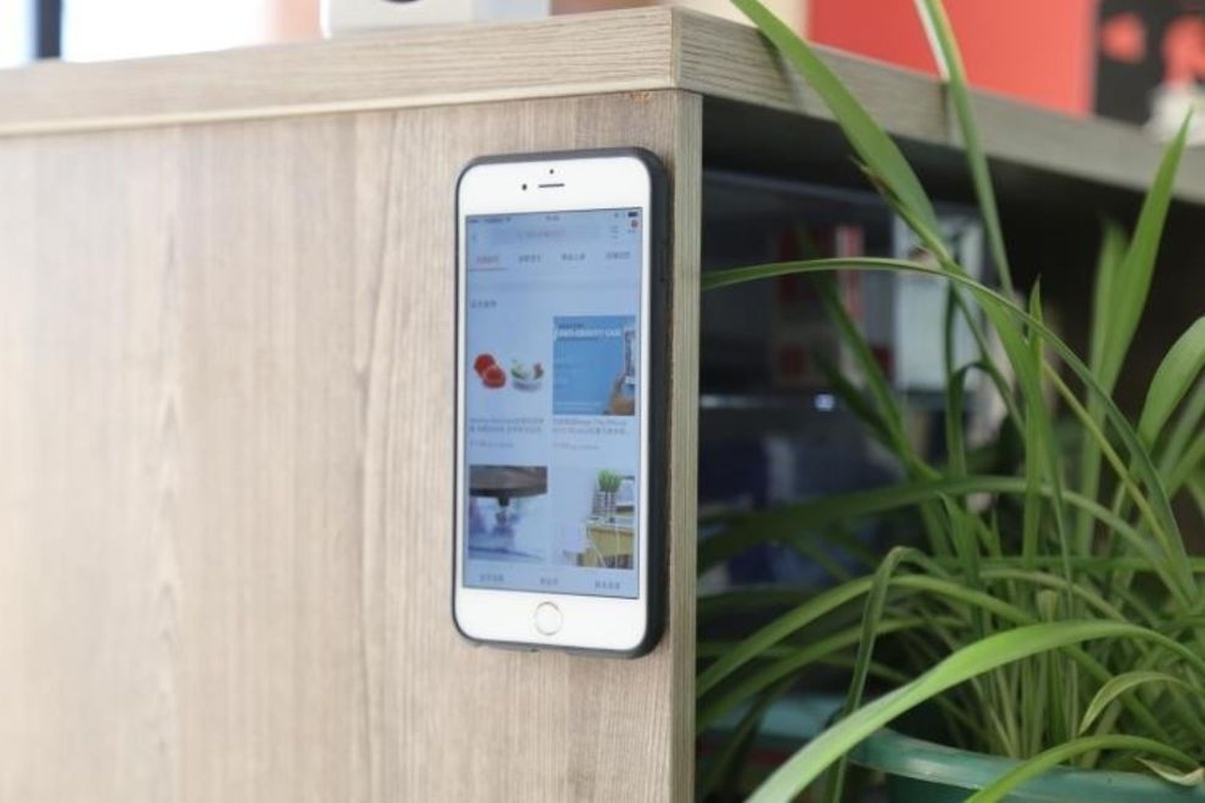 Ein Smartphone mit weißem Rahmen an einem Holzschrank befestigt, Bildschirm an.