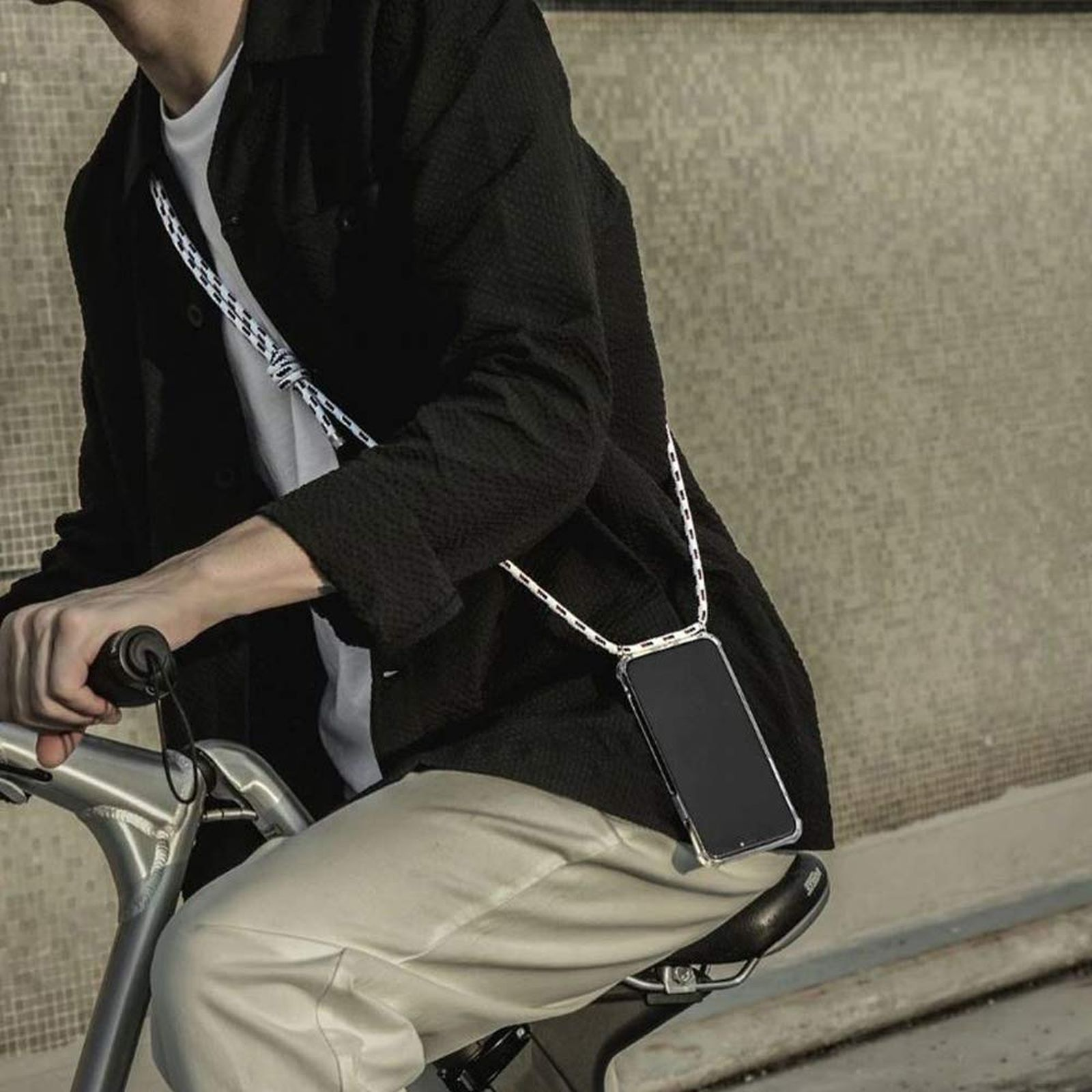 Person fährt Fahrrad mit Handy am Band. Weißes und schwarzes Band.