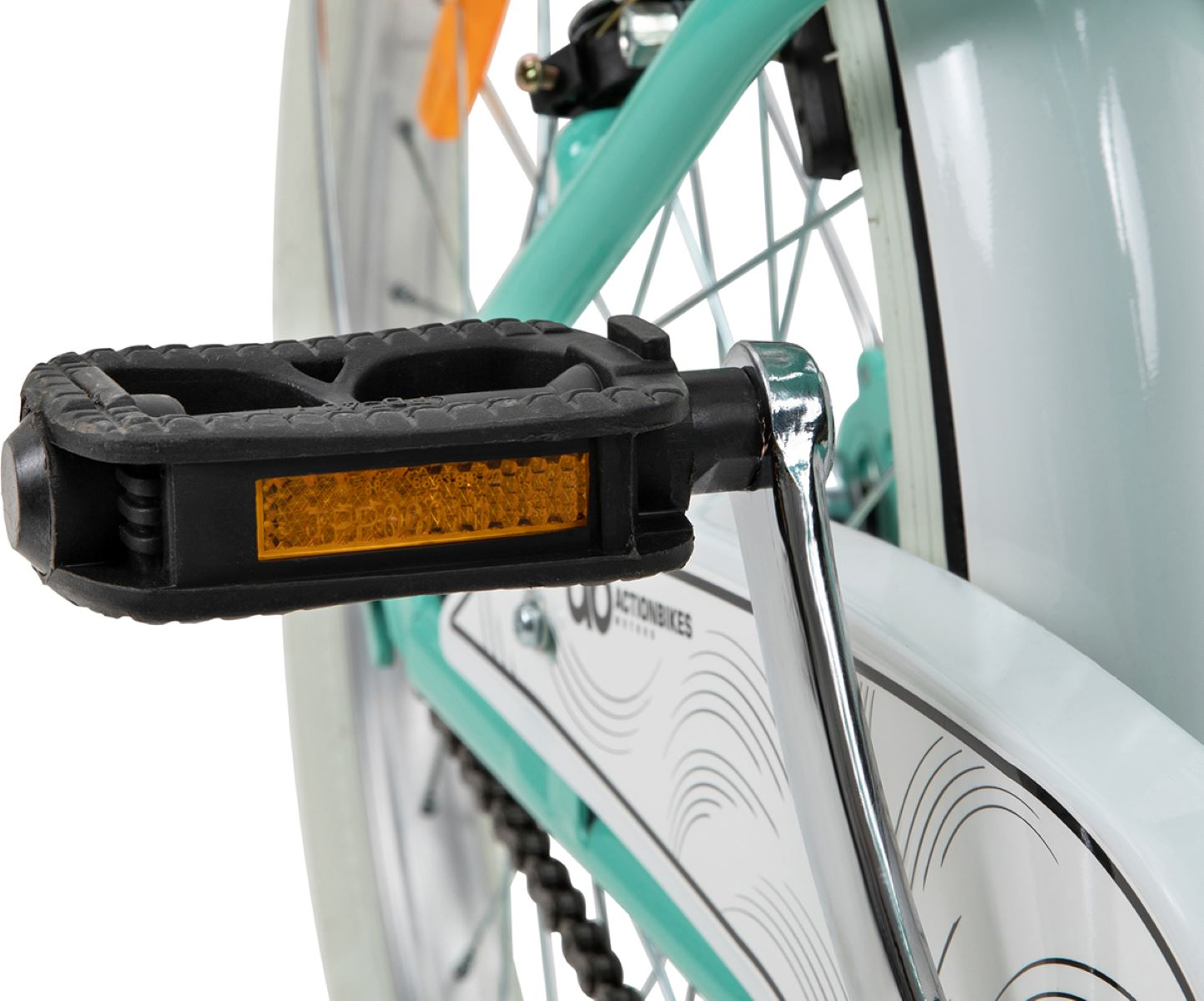 Nahaufnahme eines Fahrradpedals. Schwarz, mit gelbem Reflektor. Die Kette und ein Teil des Fahrradrahmens sind sichtbar.
