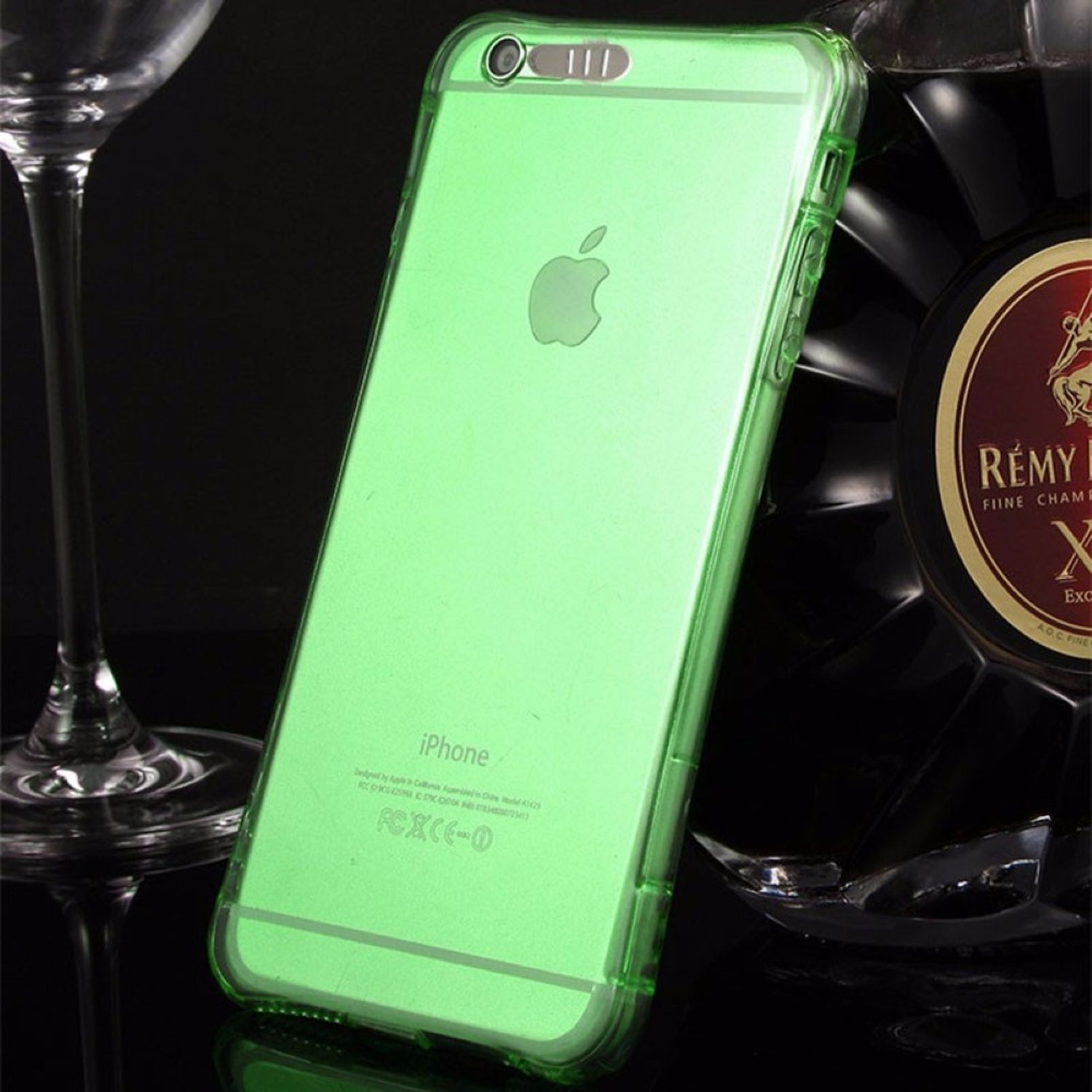 Grüne transparente iPhone-Hülle. Ein Weinglas und eine Flasche sind im Hintergrund.