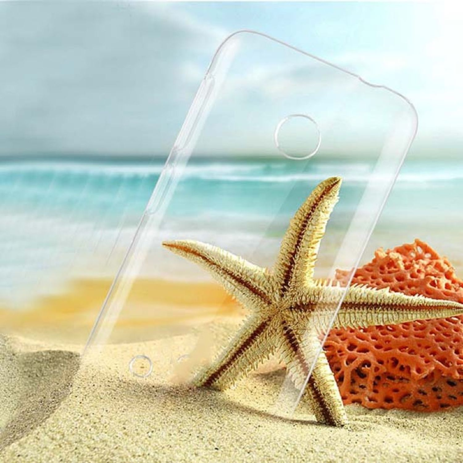 Transparente Handyhülle auf Sand. Ein Seestern und Korallen im Vordergrund. Ozean im Hintergrund.