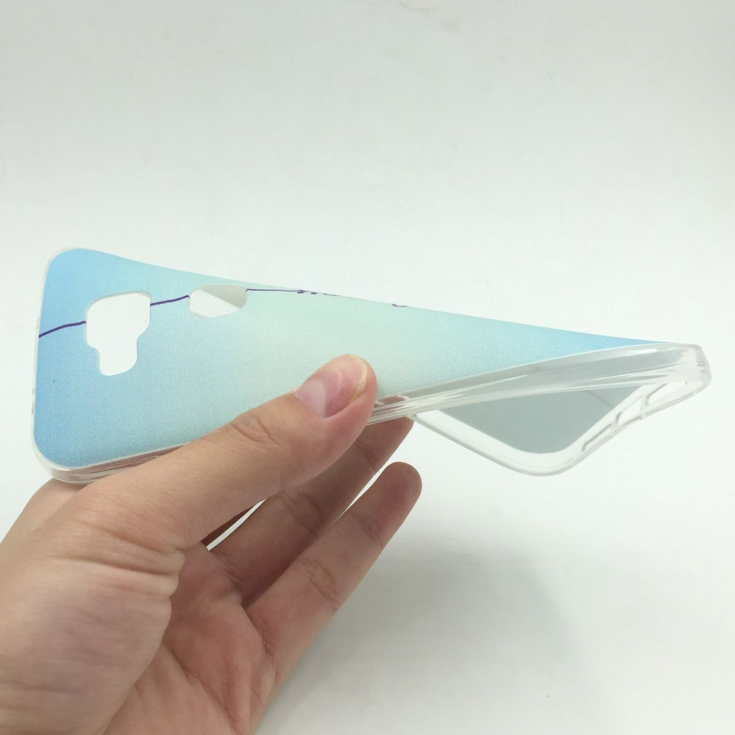 Hand hält eine transparente Handyhülle mit blau-grünem Farbverlauf.
