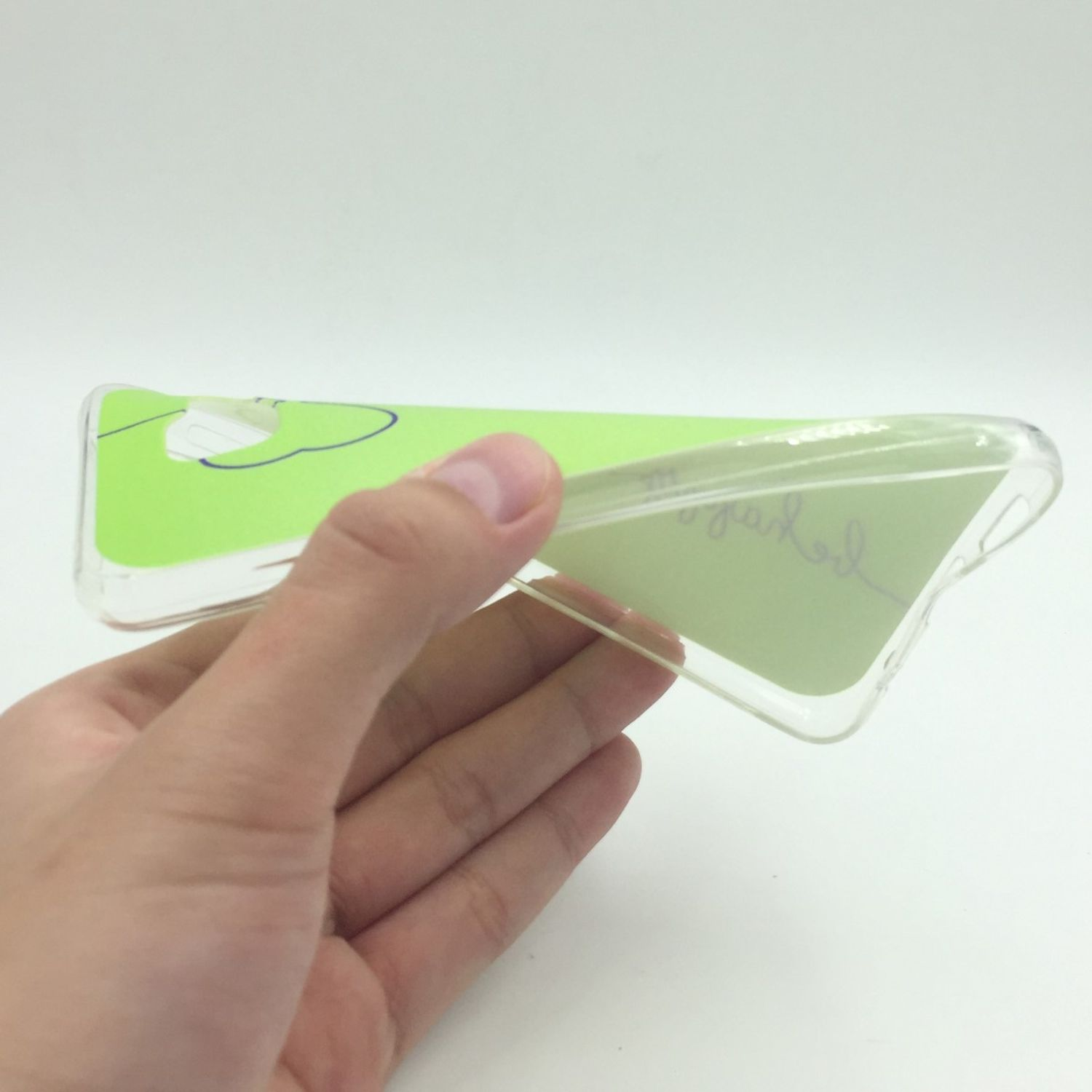 Hand hält eine klare Handyhülle. Es hat ein grün-weißes Design.