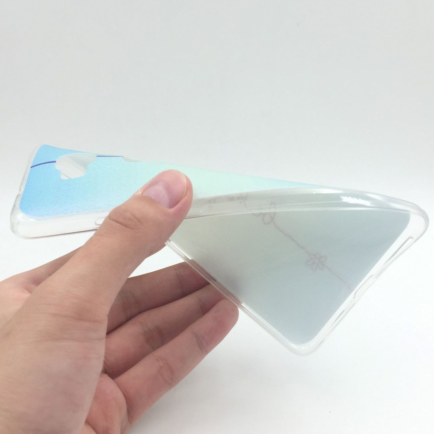 Eine Hand hält eine transparente Handyhülle und zeigt deren Flexibilität. Die Hülle hat einen blau-grünen Farbton.