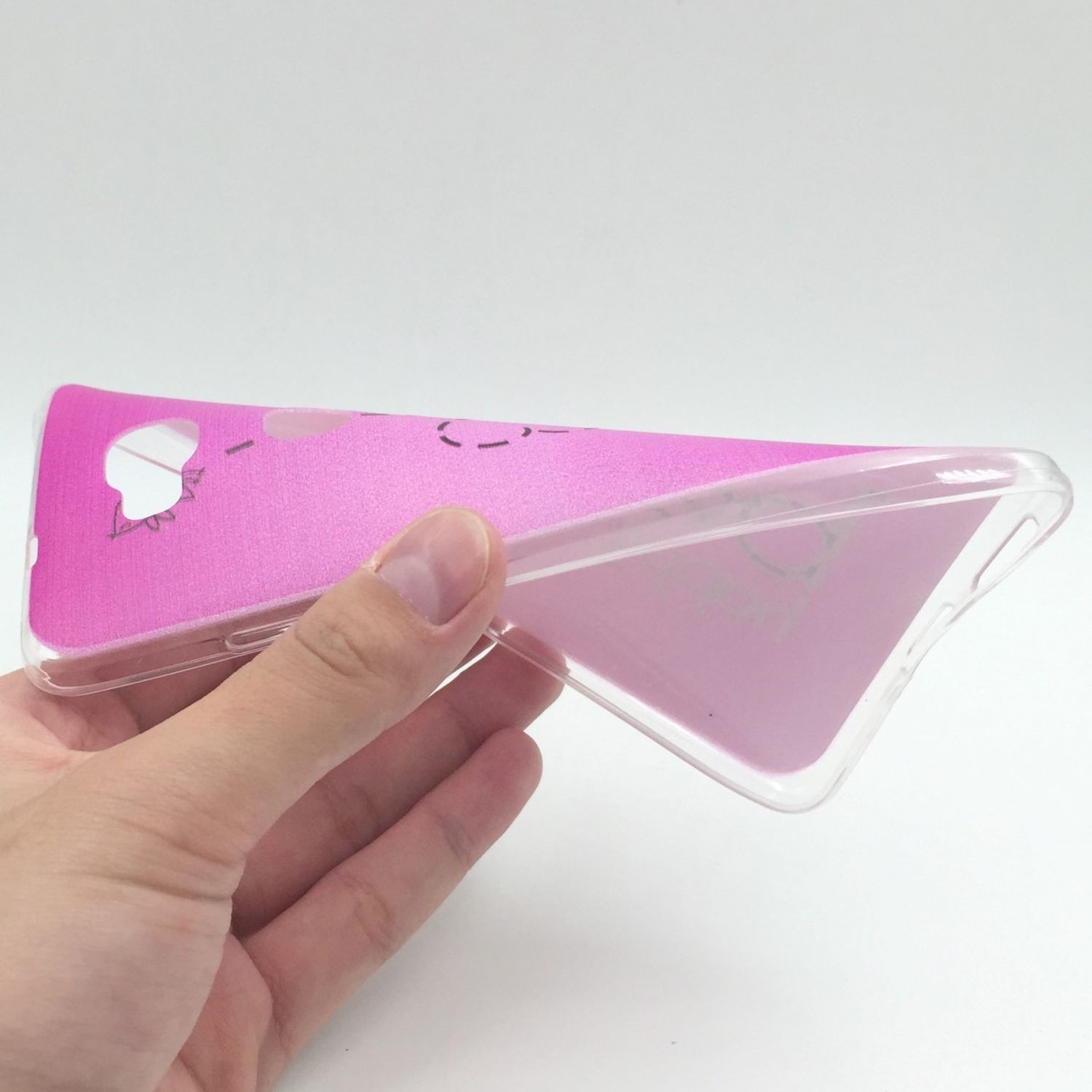 Eine Hand, die eine rosa Handyhülle mit Cartoon-Design hält, aus einem niedrigen Winkel gesehen.