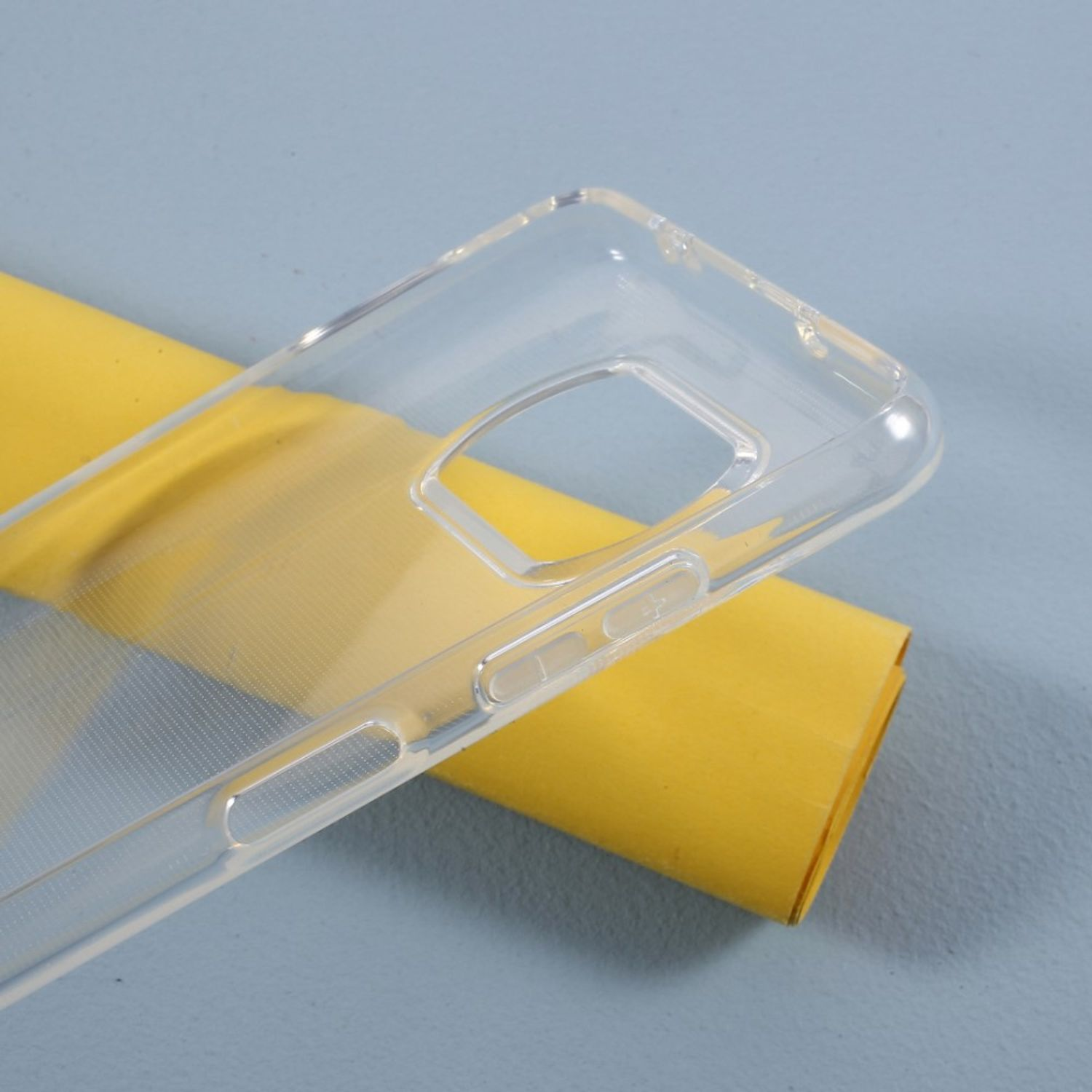 Transparente Handyhülle auf gelbem Papier. Die Hülle ist transparent. Das Papier ist im Hintergrund.
