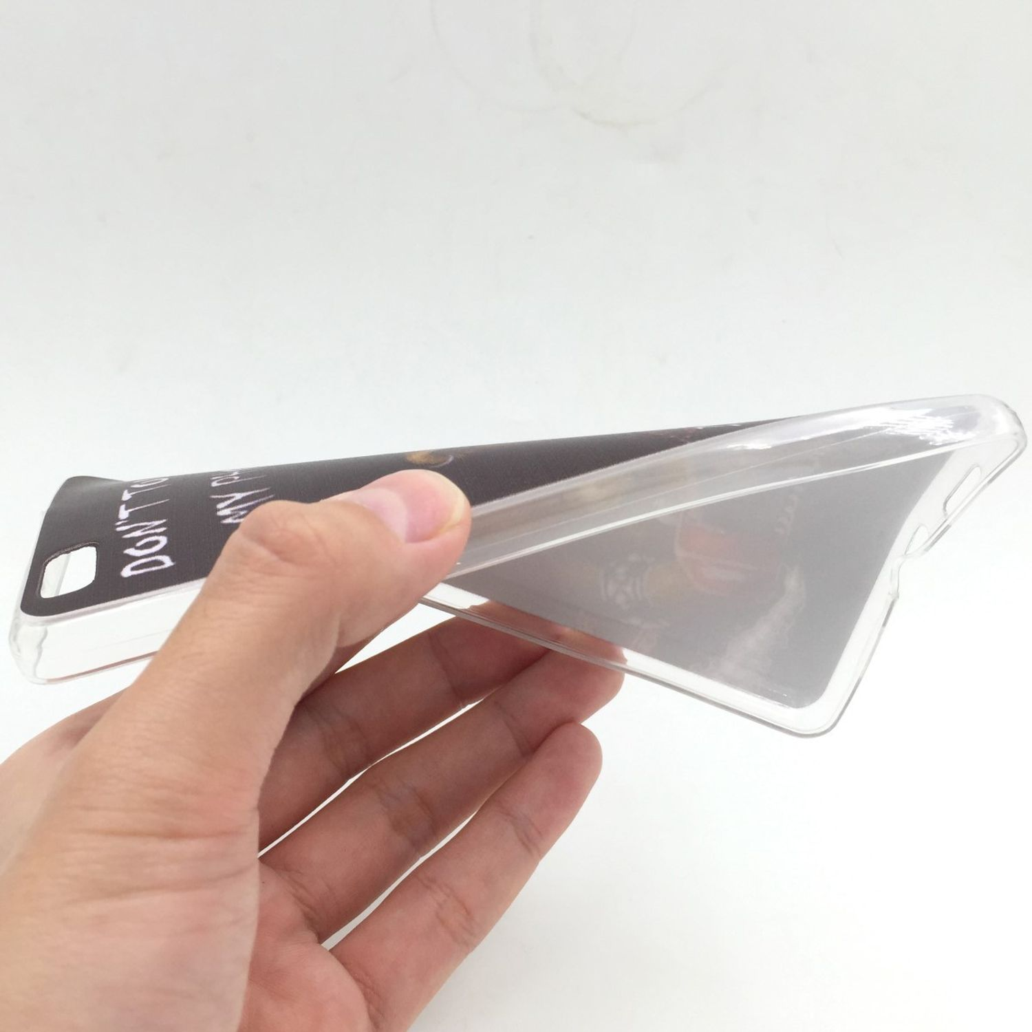 Eine Hand, die eine transparente Handyhülle hält, die ein verschwommenes Design auf weißem Hintergrund zeigt.