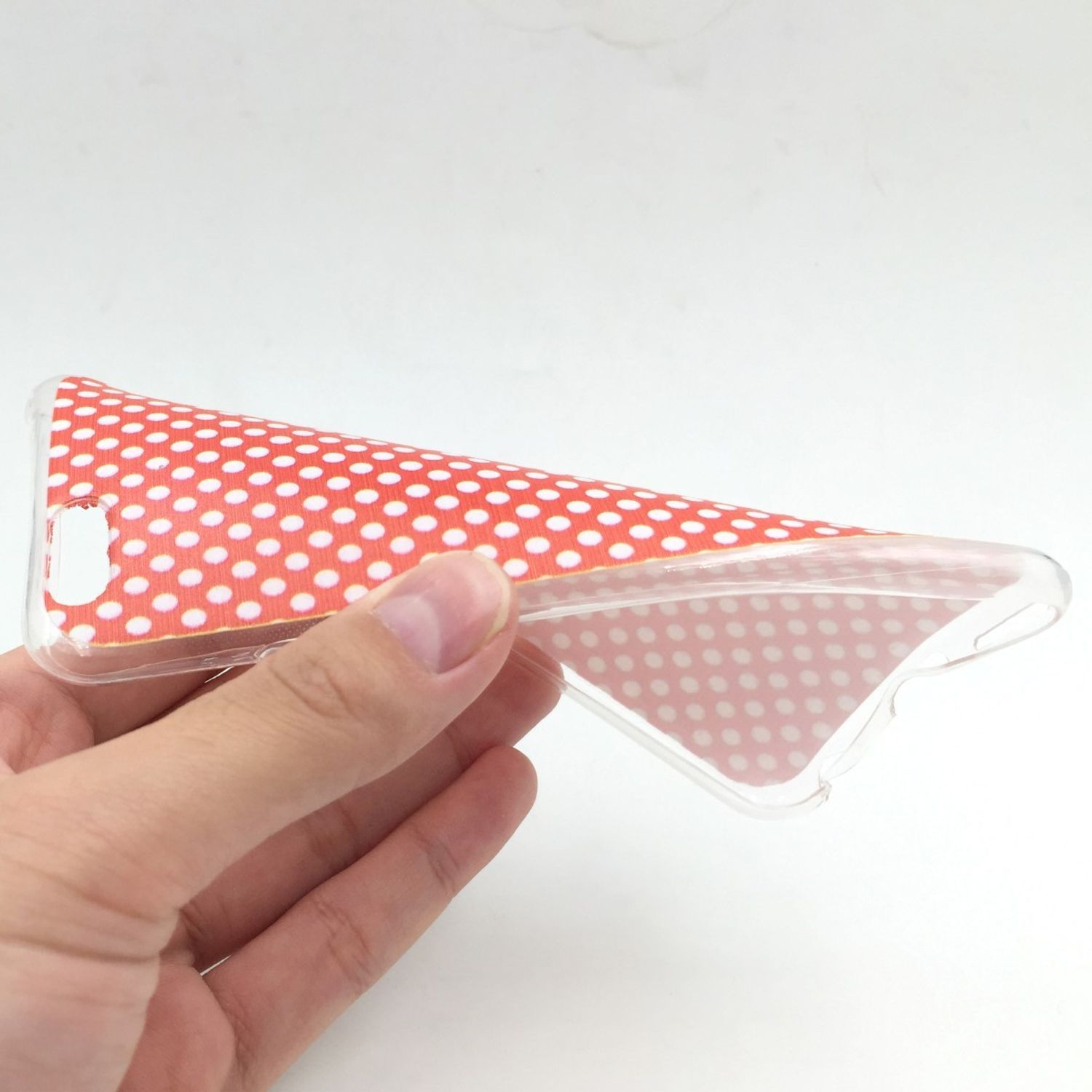 Hand hält eine Handyhülle mit Polka Dots.