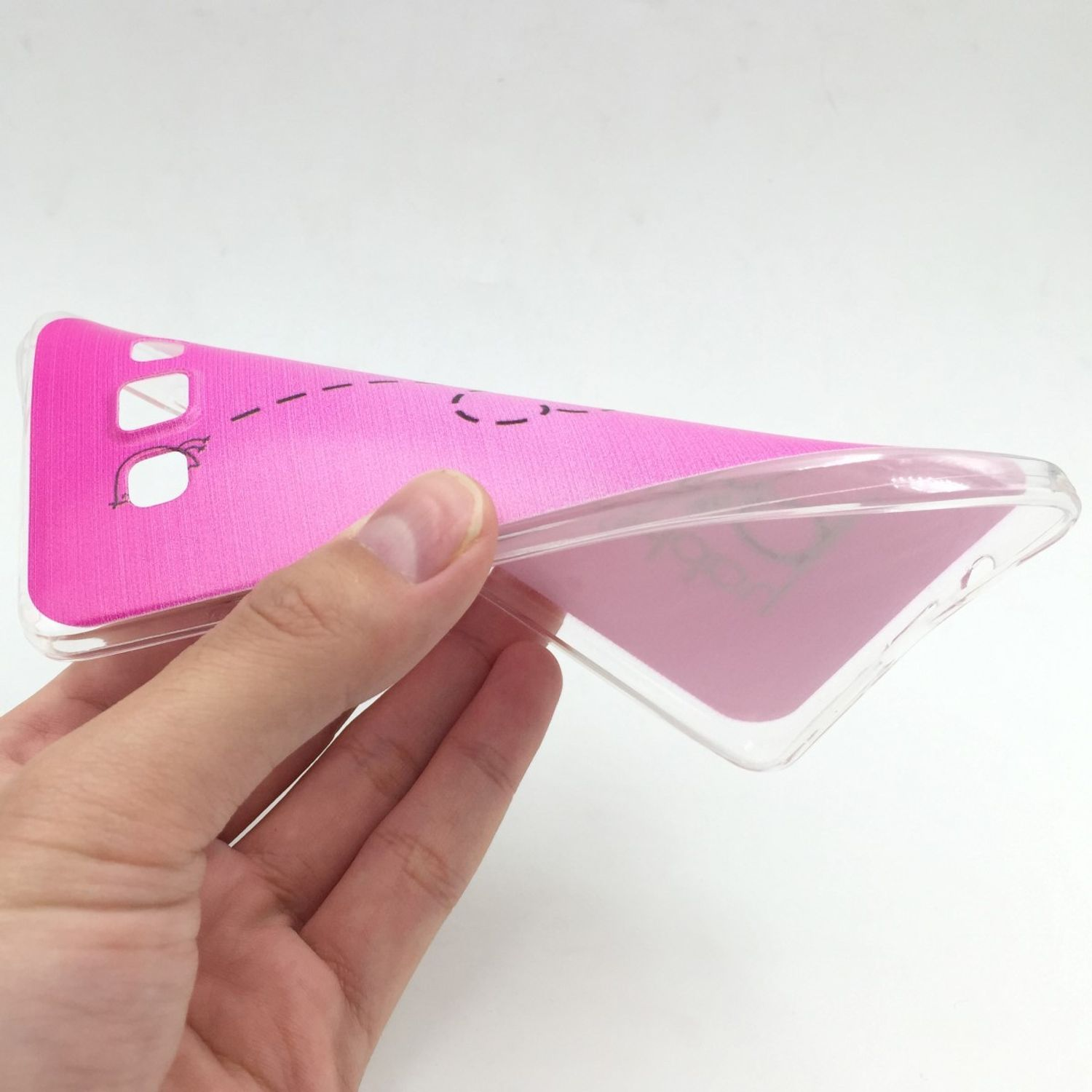 Hand hält flexible rosa Handyhülle mit gedrucktem Muster und transparentem Rand.