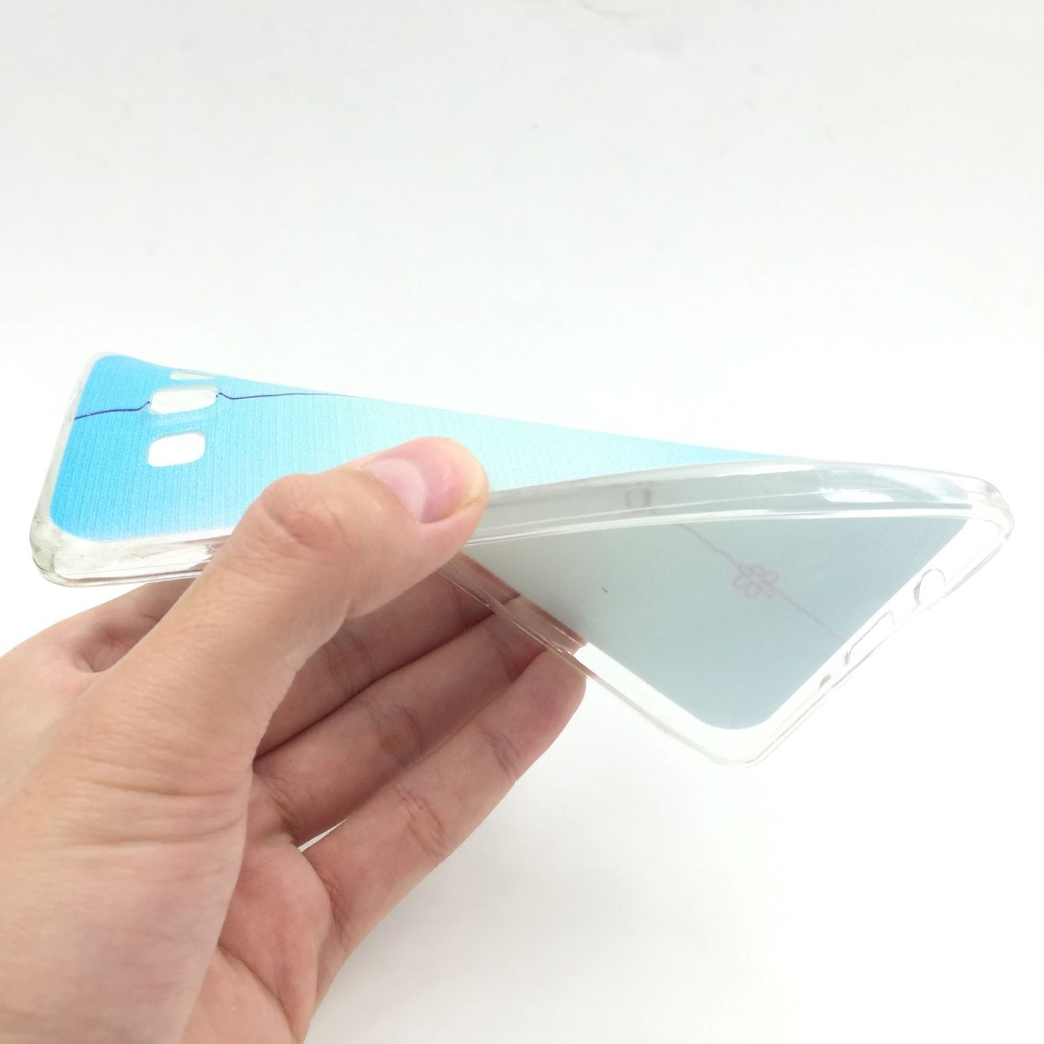 Hand hält eine transparente Handyhülle mit blauem Farbverlauf auf der Rückseite.