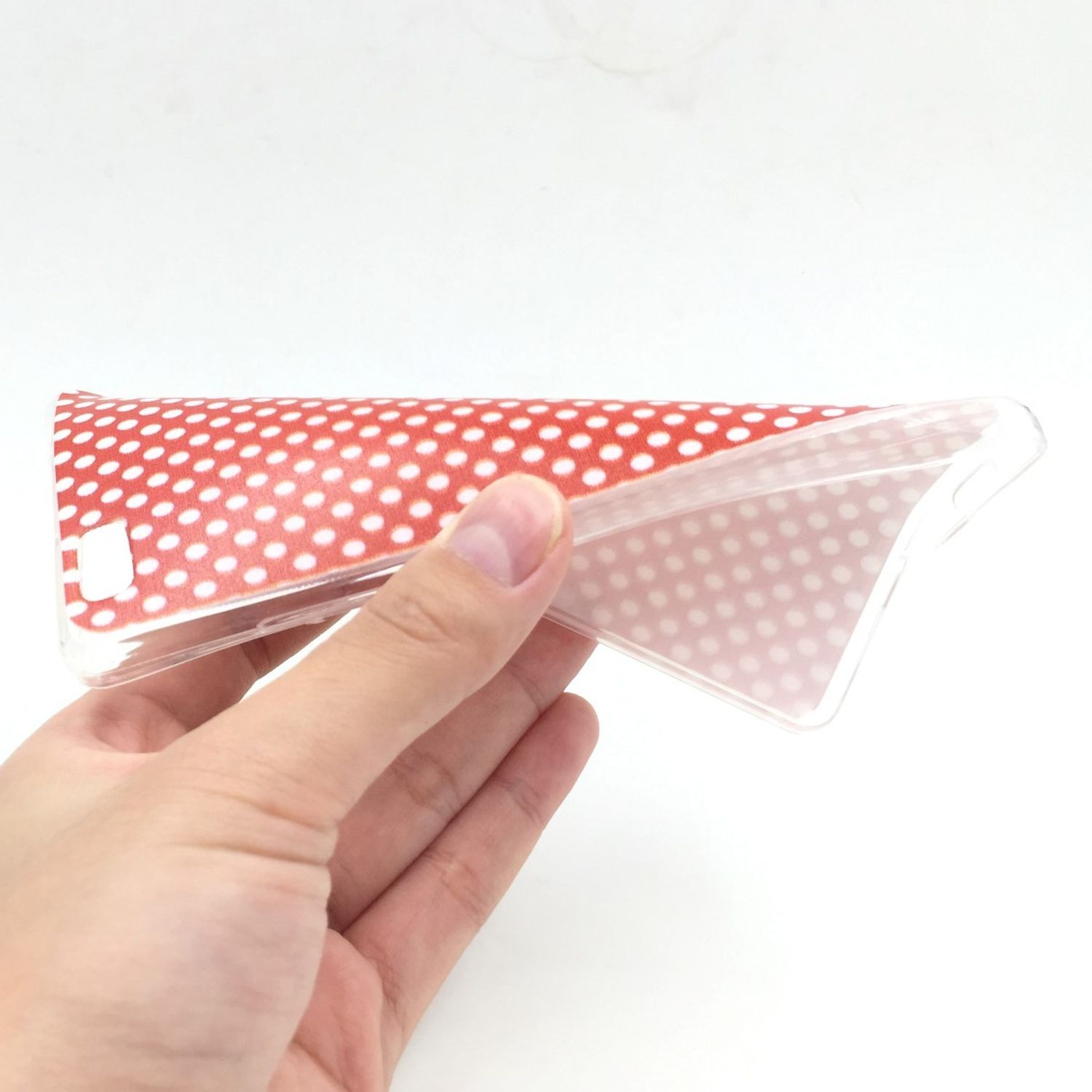 Hand hält eine transparente Handyhülle mit roten Punkten. Die Hülle ist leicht gebogen.