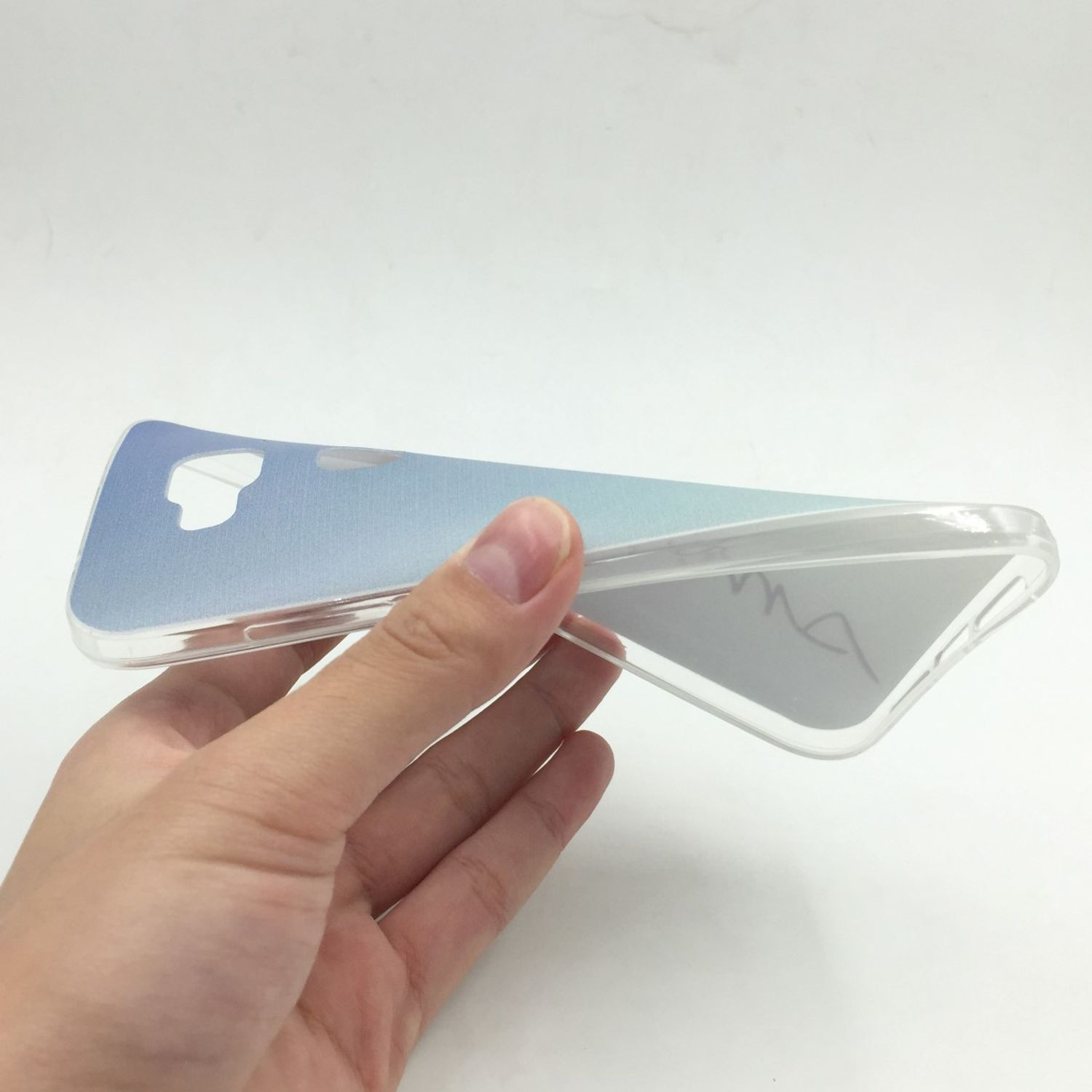 Eine Hand, die eine transparente Handyhülle mit blau-weißem Farbverlauf hält.