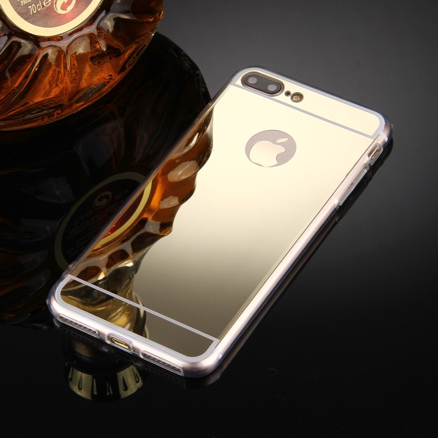 Goldene Handyhülle mit silbernem Rand. Schwarzer Hintergrund. Apple-Logo sichtbar.