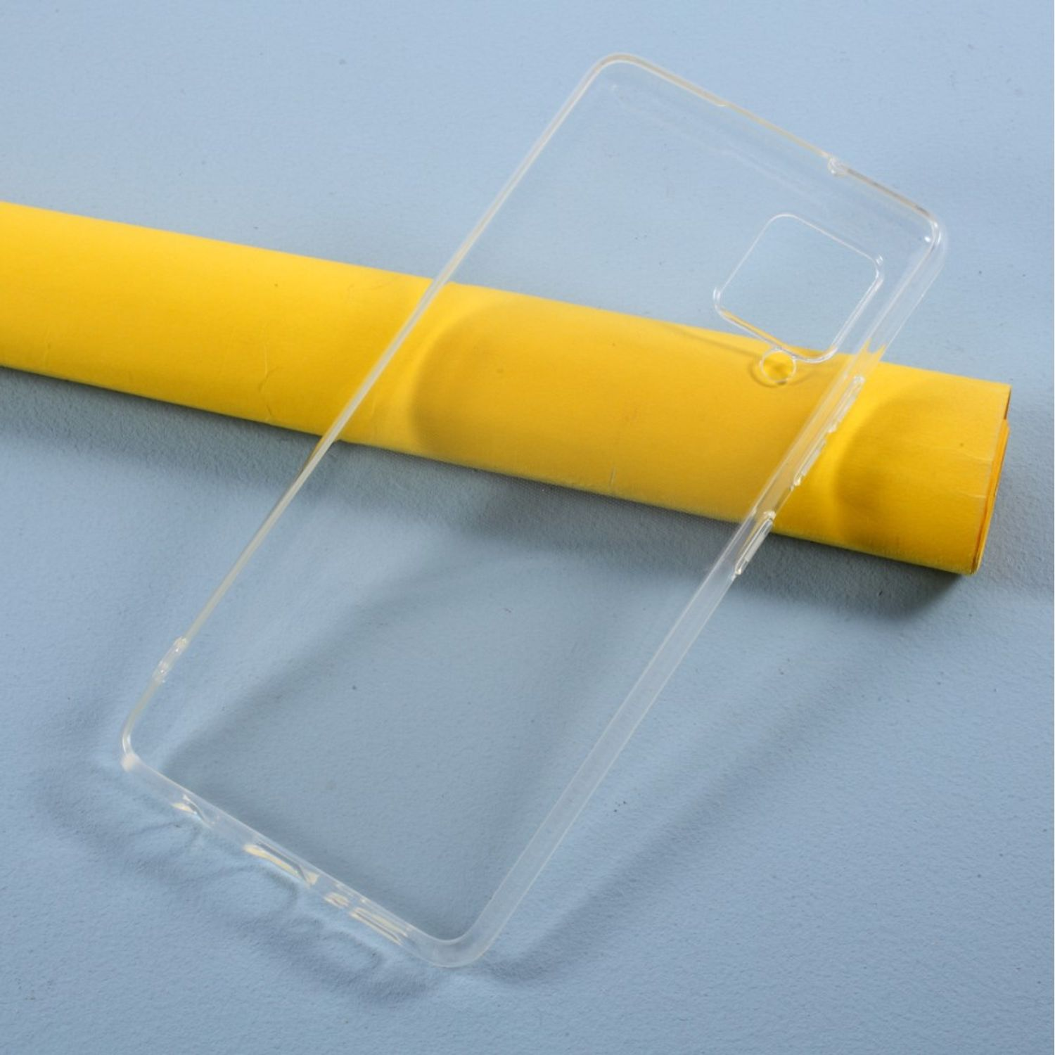 Transparente Handyhülle und eine gelbe Rolle. Die Hülle befindet sich auf blauem Hintergrund.