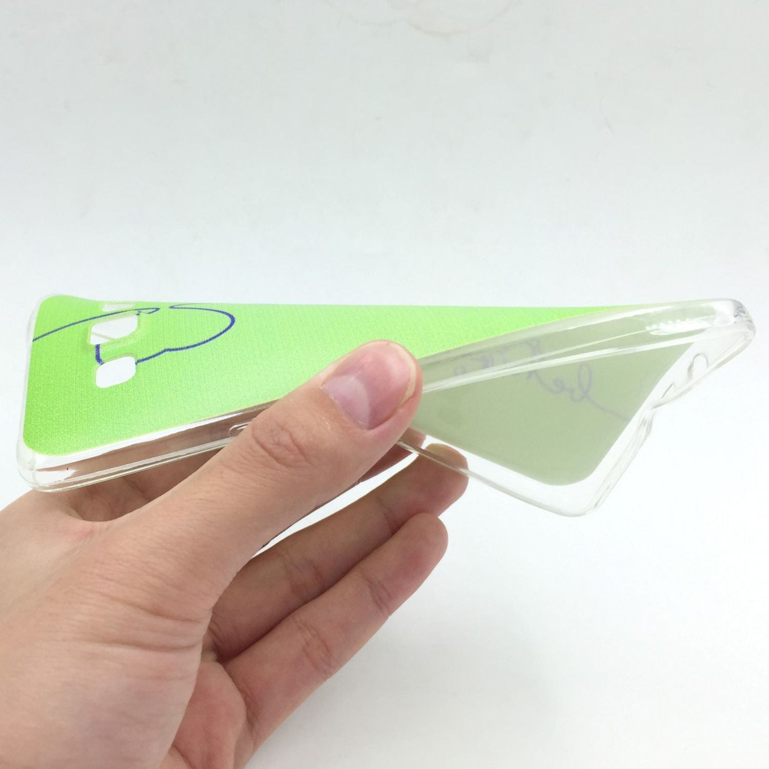 Eine Hand hält eine transparente Handyhülle mit grünem Farbverlauf.