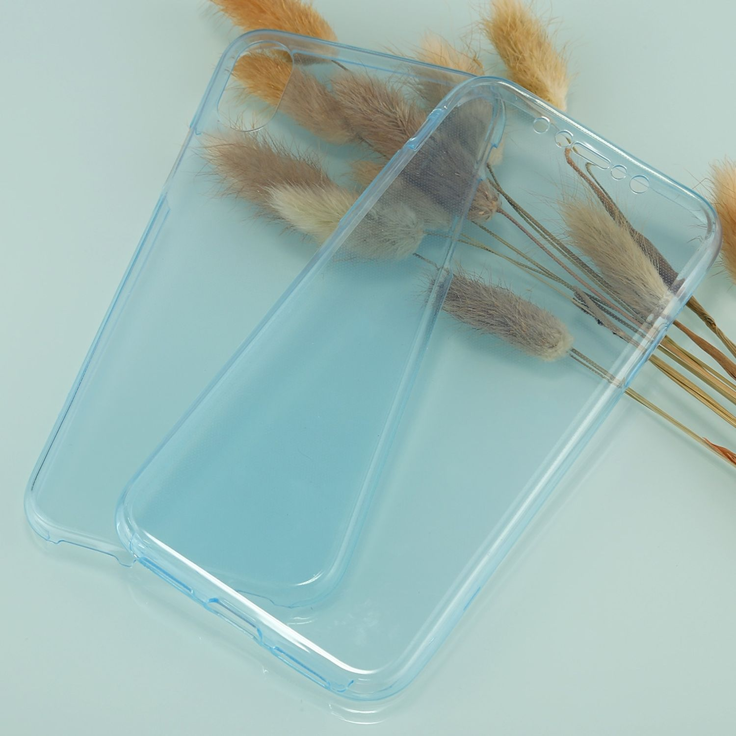 Zwei transparente blaue Handyhüllen mit Pflanzen dahinter auf hellblauem Untergrund.