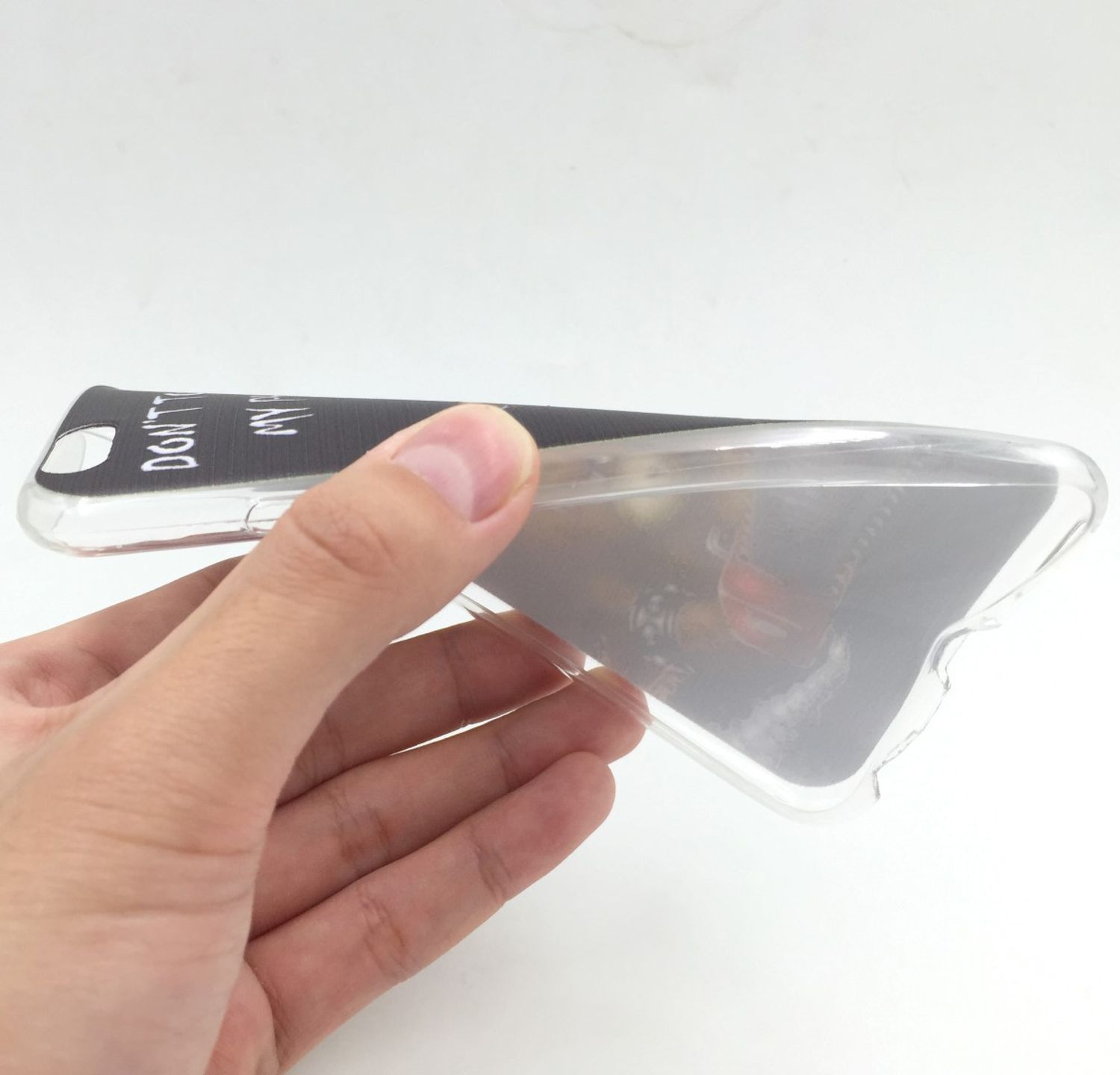 Eine Hand hält eine transparente Handyhülle mit einem Design. Der Hintergrund ist weiß.