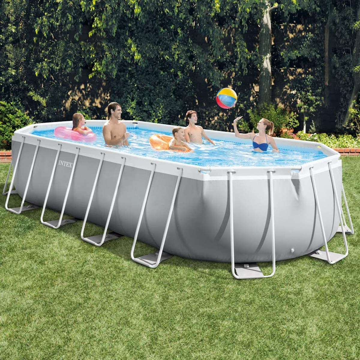 Menschen in einem Pool im Freien spielen mit einem Ball, Bäume im Hintergrund.