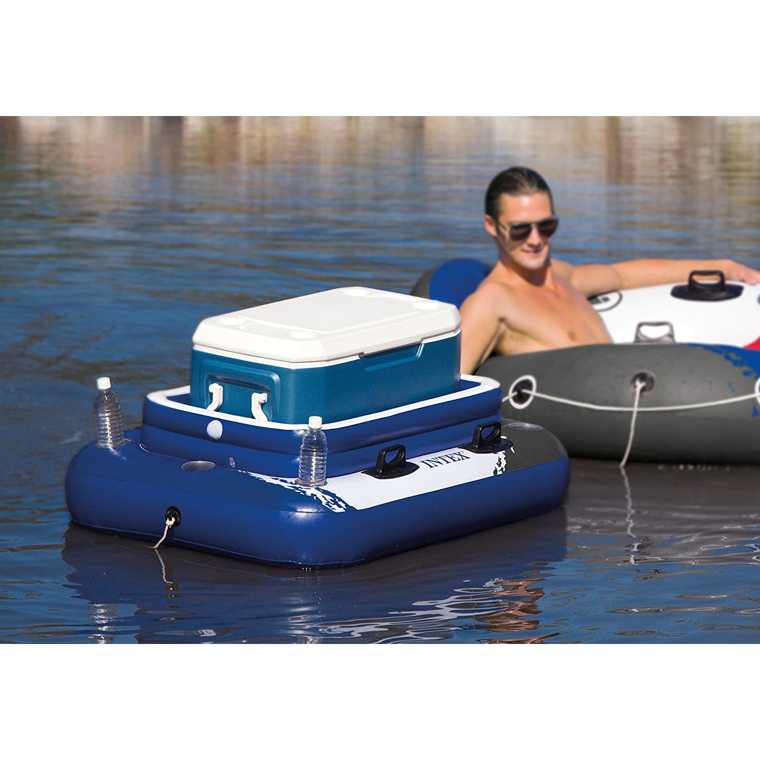 Blauer und weißer schwimmender Kühler mit einer Person im Wasser und einem zweiten Schwimmer.