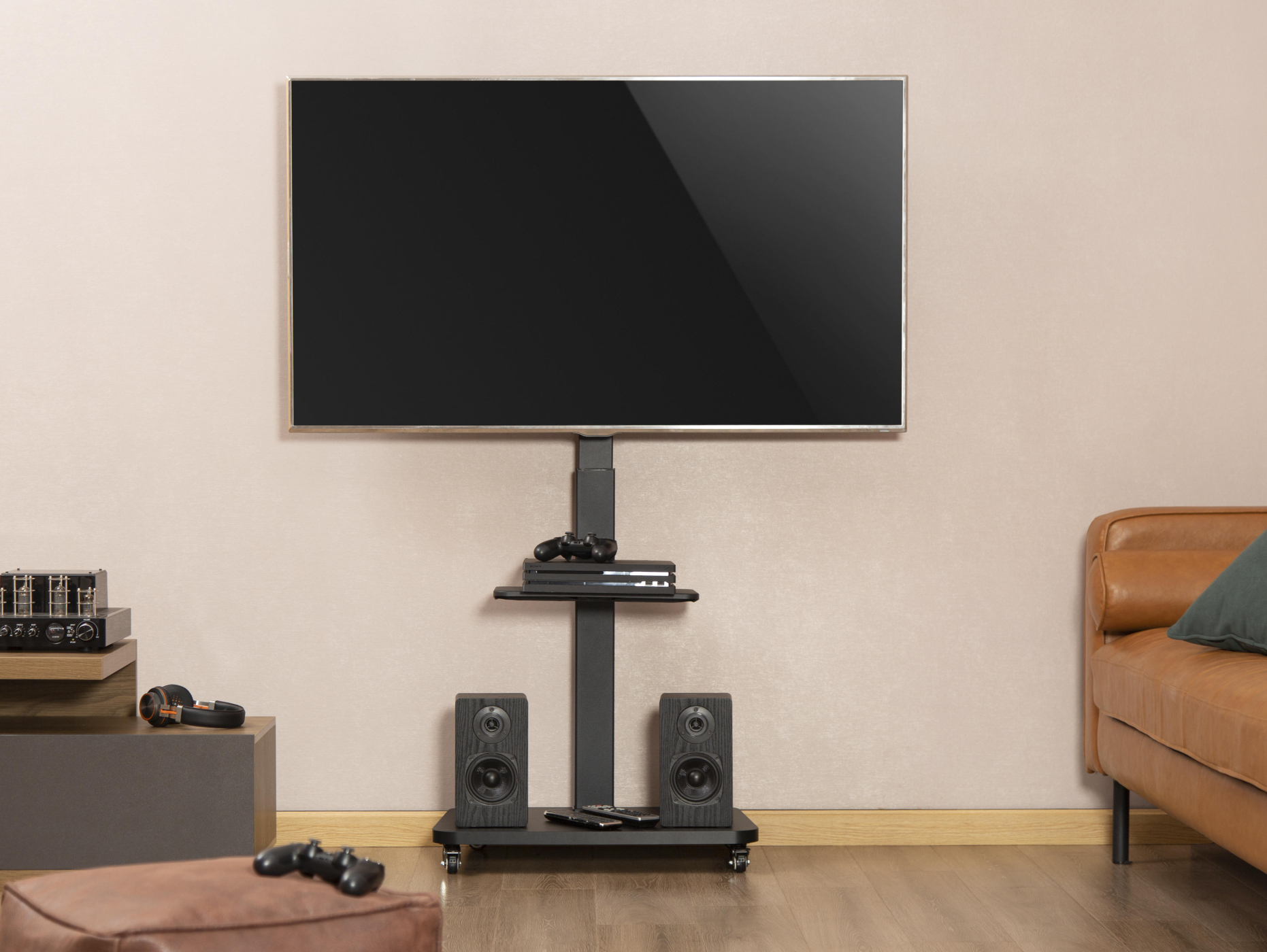 Ein Fernseher auf einem schwarzen Ständer mit Lautsprechern und Konsolen.