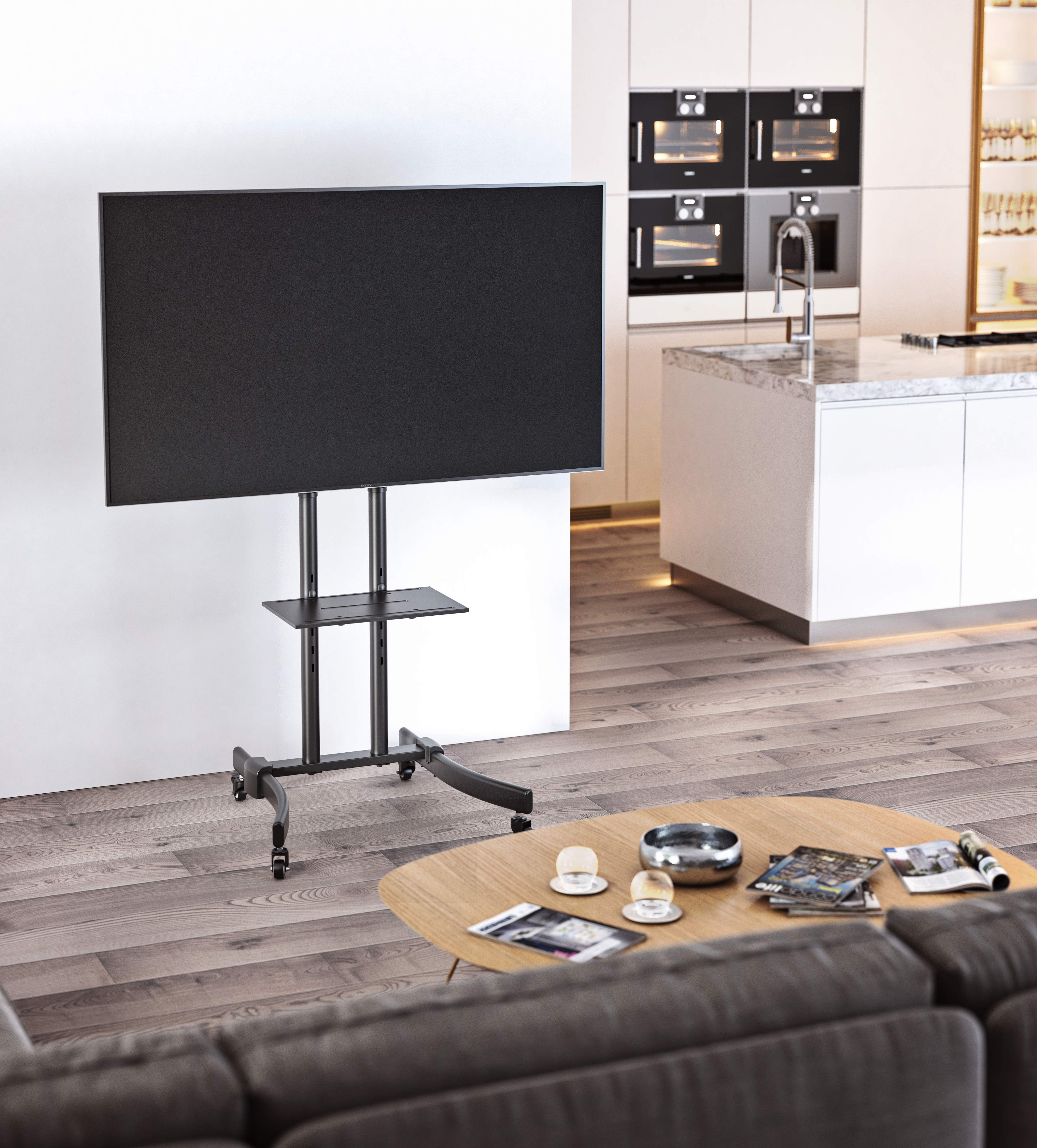 Fernseher auf schwarzem Ständer mit Regal, auf Rädern. Holzboden, Couchtisch mit Zubehör, in einem modernen Zuhause.