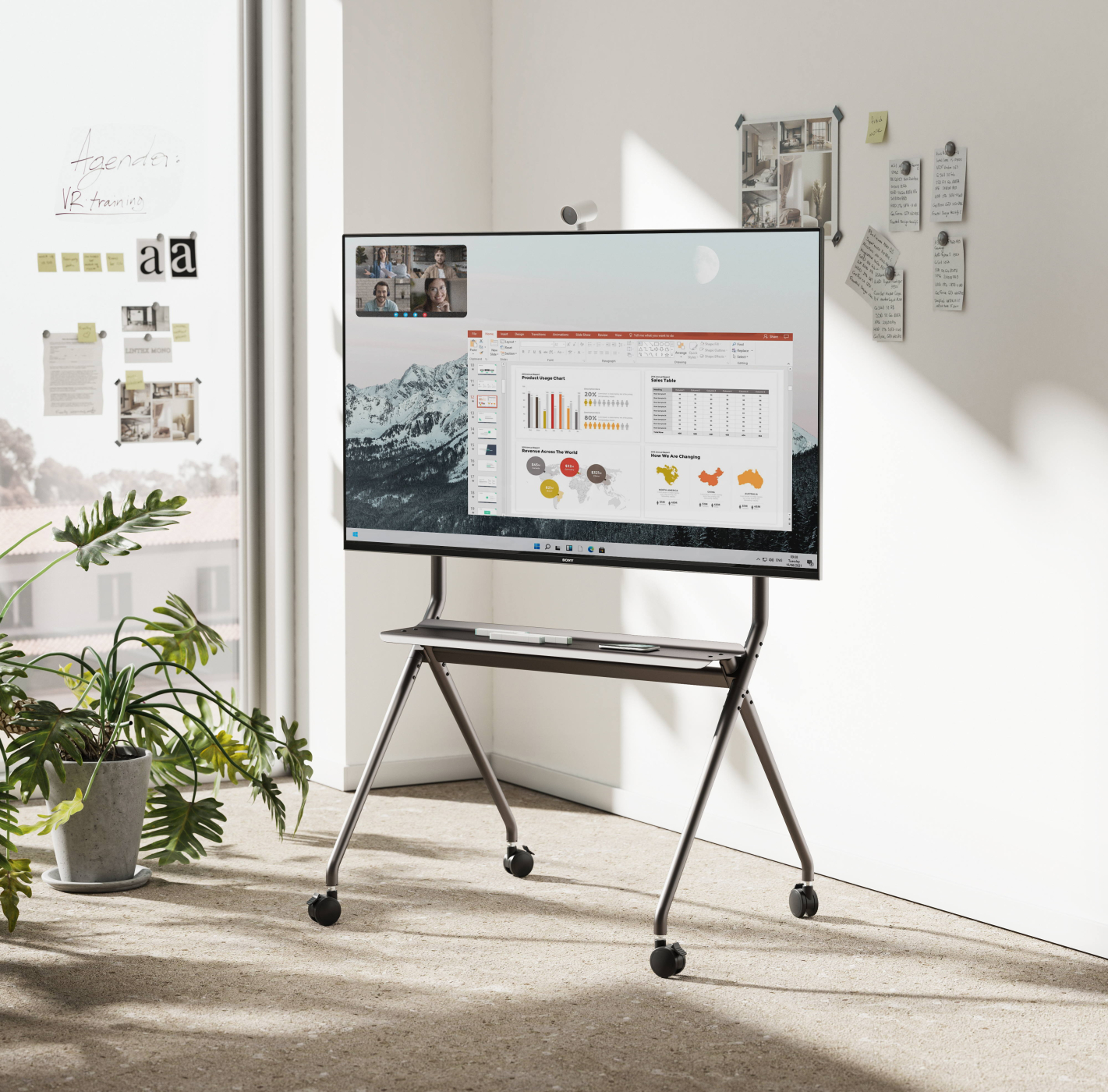 Modernes Büro mit Fernseher auf einem Ständer. Personen in einem Videoanruf auf dem Bildschirm.