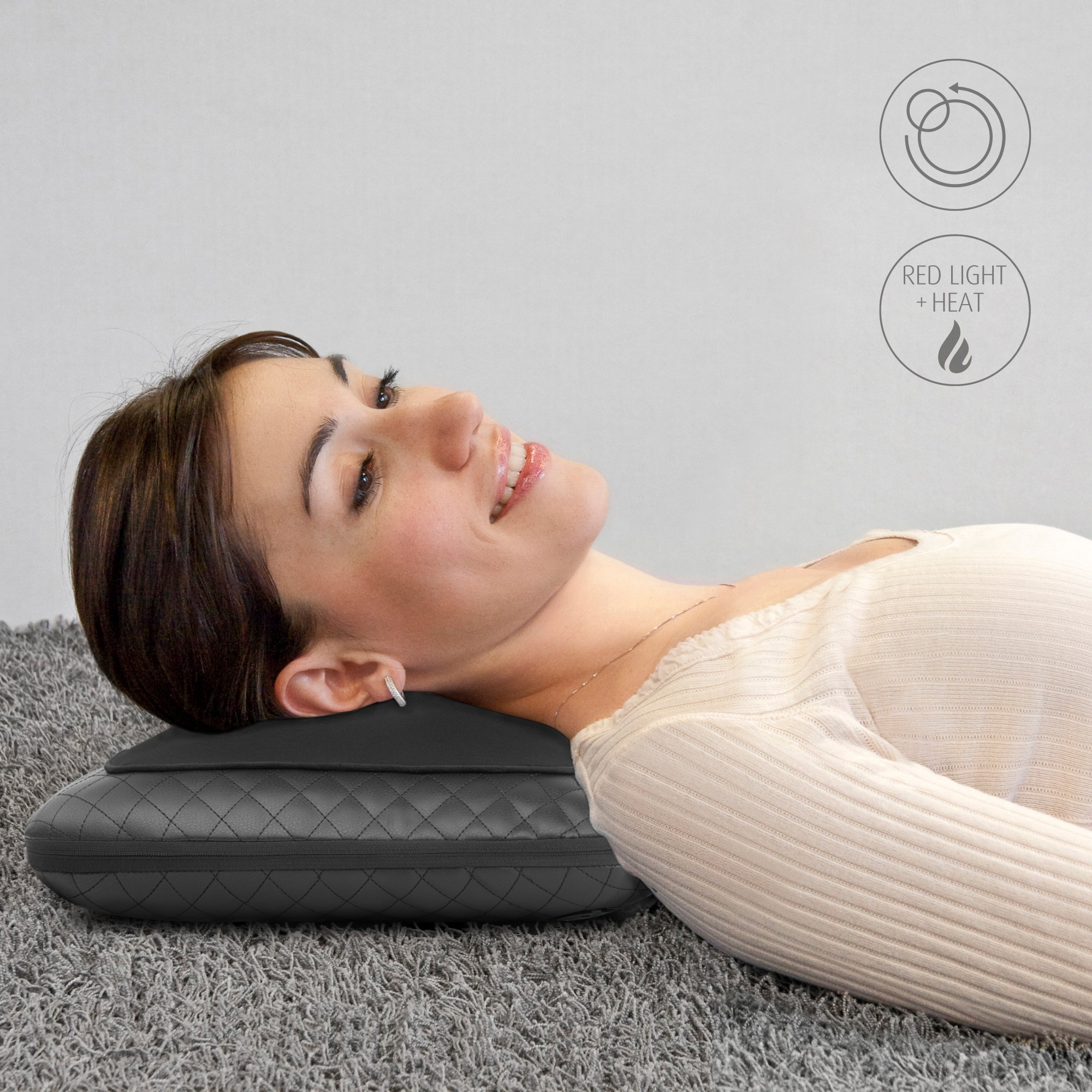 Una mujer acostada sobre una alfombra gris con una almohada negra bajo el cuello. Símbolos de luz roja y calor.