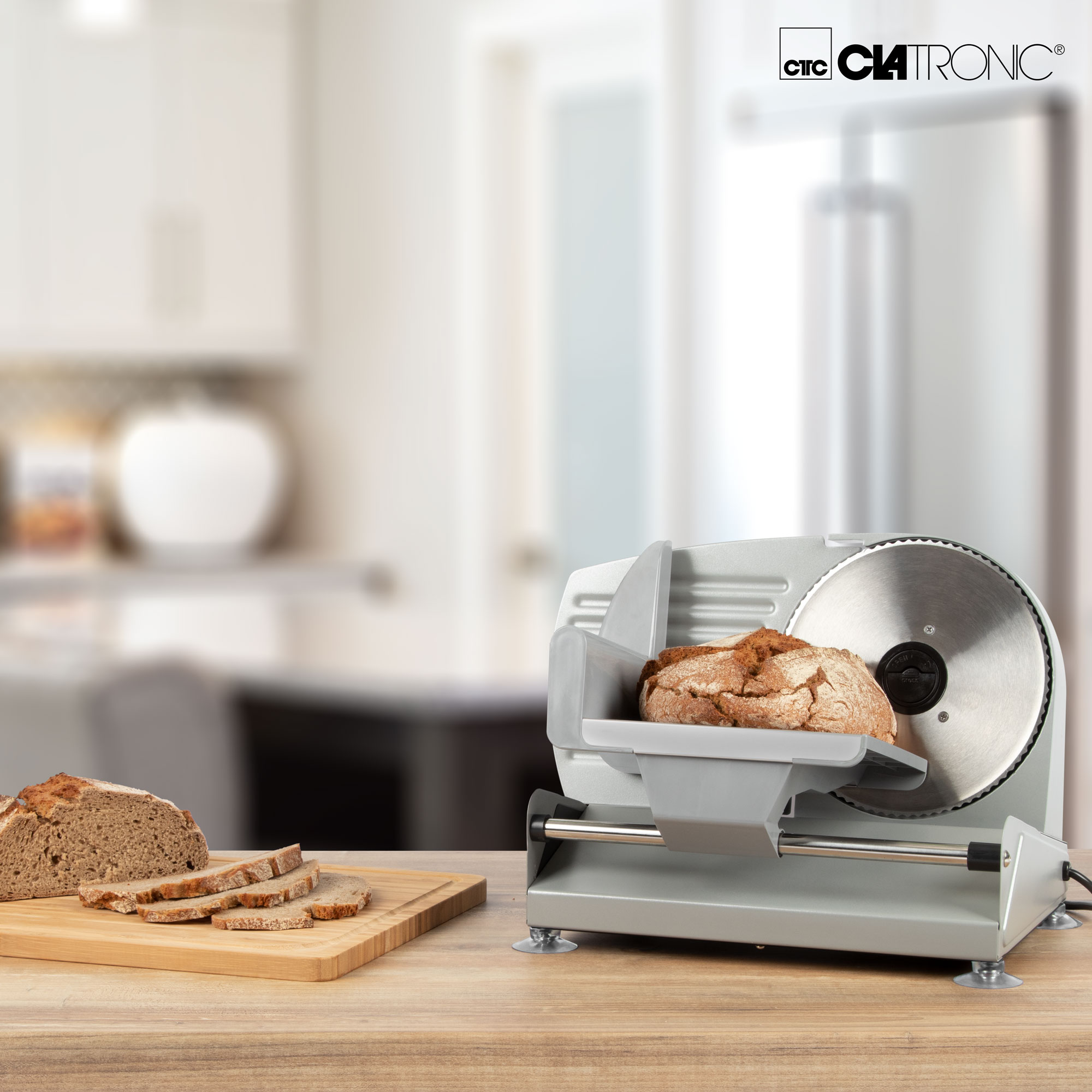 Krajalnica do chleba na stole. Widoczny jest pokrojony chleb i deska do krojenia.