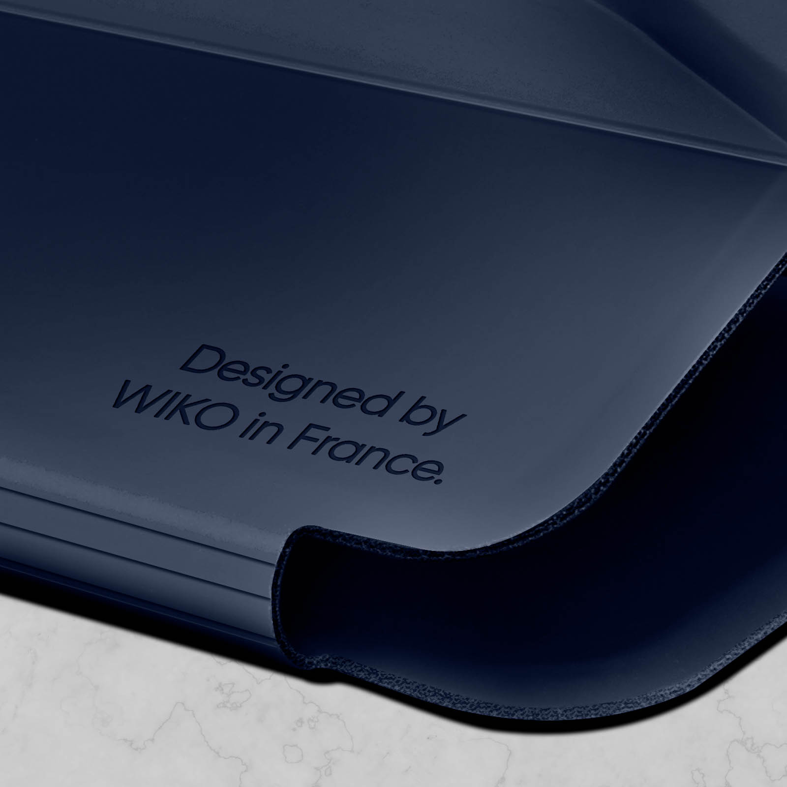 Superficie blu scuro. Testo: 'Designed by WIKO in France'.