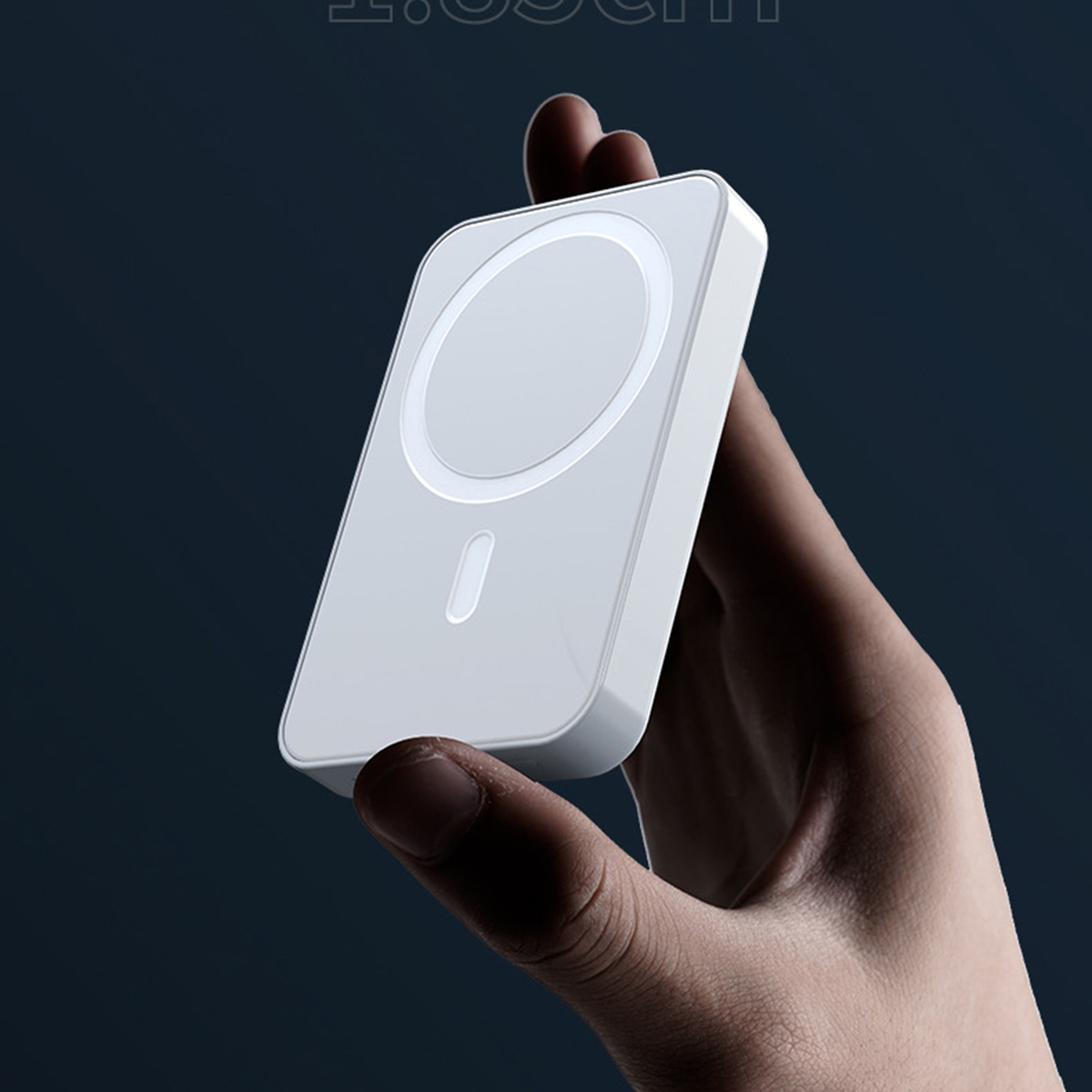 Cargador portátil blanco con área circular. Sostenido por una mano contra un fondo azul.