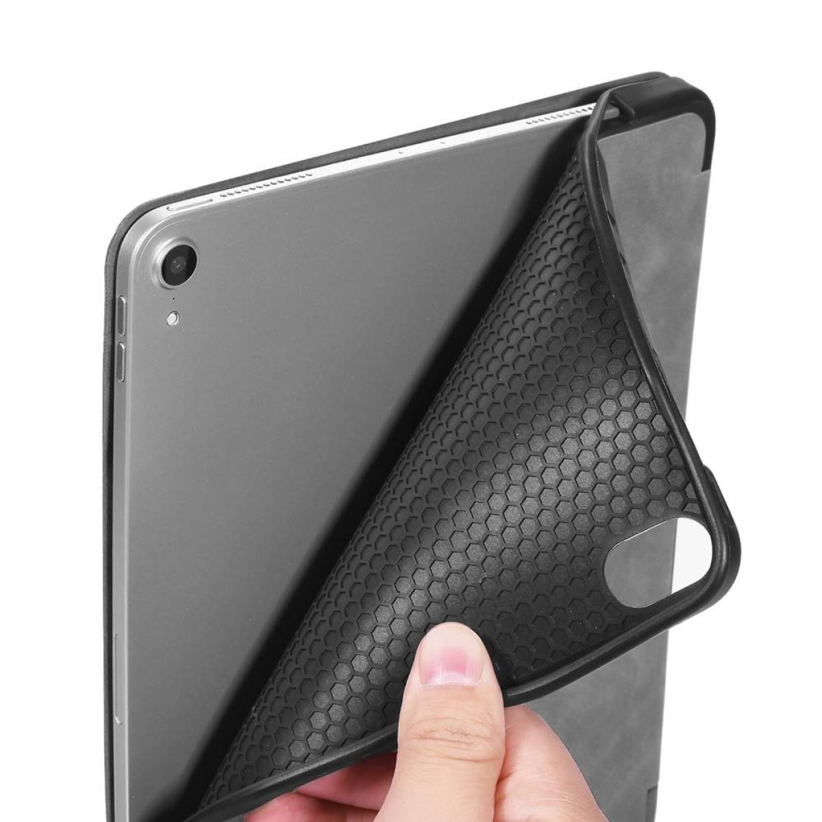 Eine Hand zieht eine schwarze, strukturierte Tablethülle von einem grauen Tablet ab.