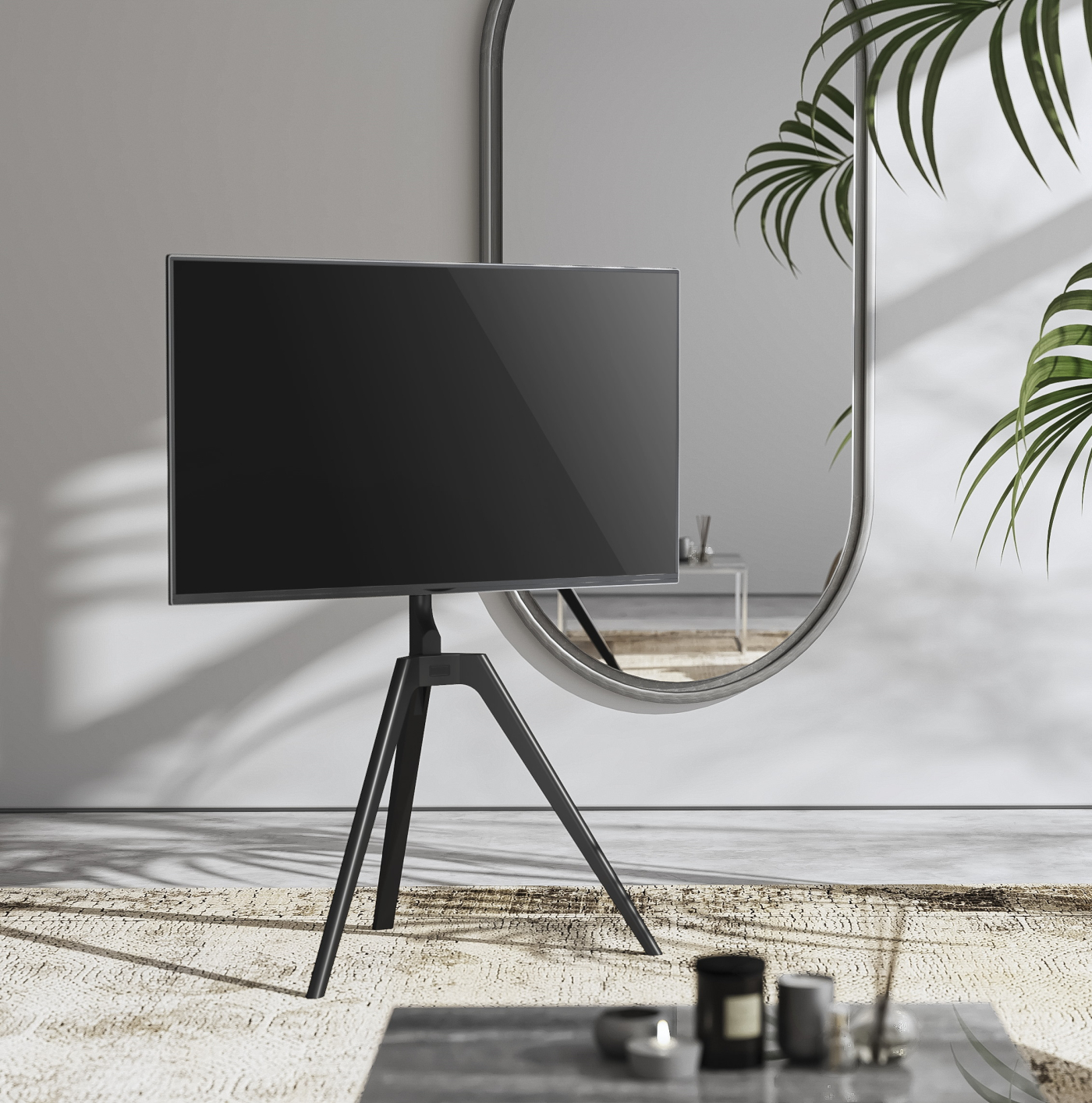 Moderne tv op een statief. Een spiegel en planten staan op de achtergrond.