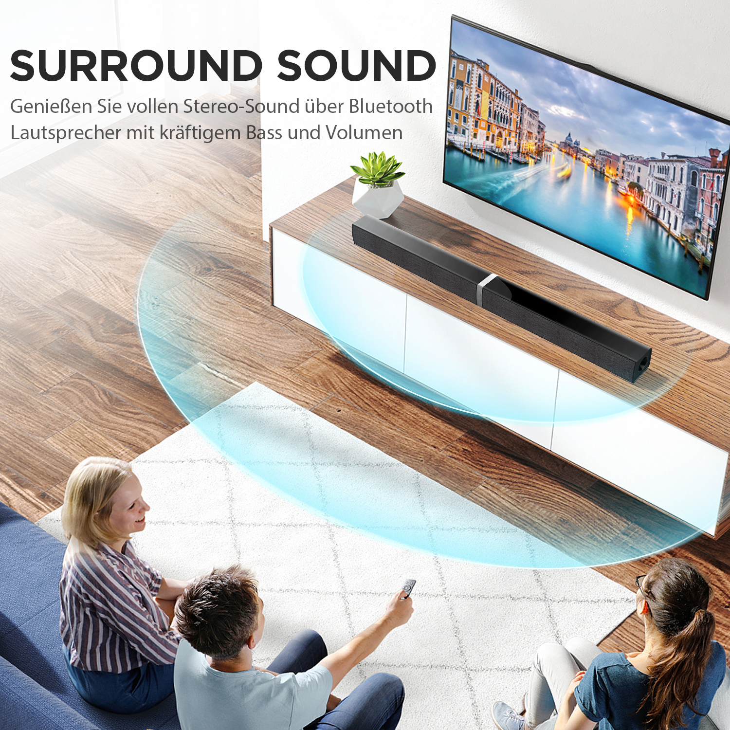 Zwei Personen schauen fern mit einer Soundbar. Die Soundbar steht auf einem weißen Schrank.