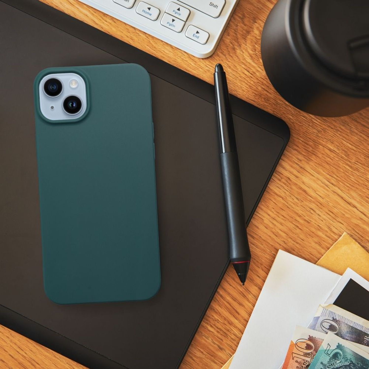 Draufsicht auf einen Schreibtisch mit Telefon, Stift und anderen Gegenständen. Holzoberfläche.