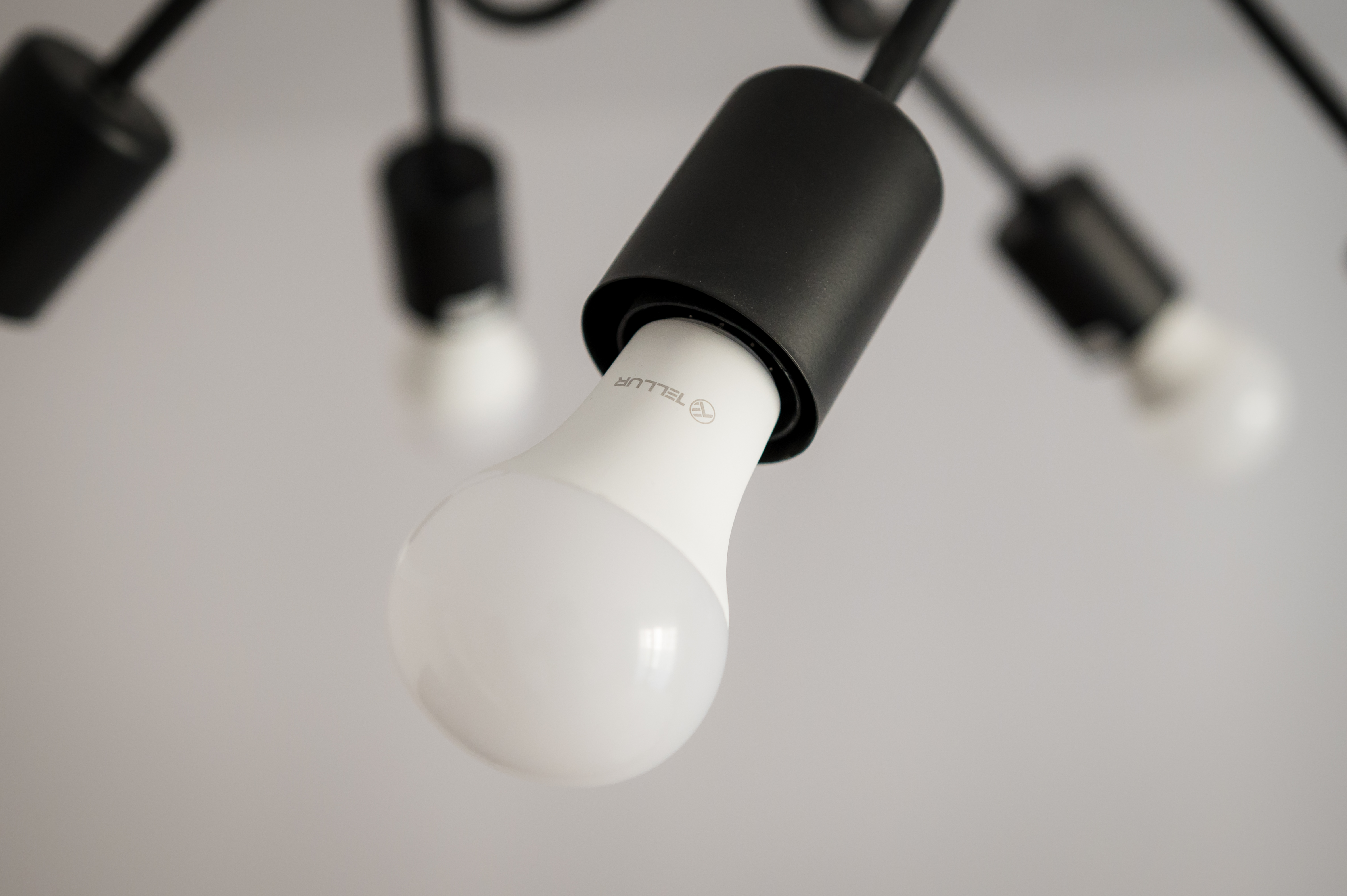 Zbliżenie oprawy oświetleniowej. Żarówka jest biała, a oprawa czarna.