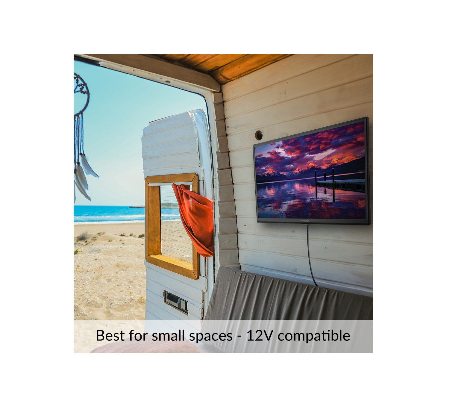 Telewizor zamontowany na drewnianej ścianie w pojeździe z widokiem na plażę.