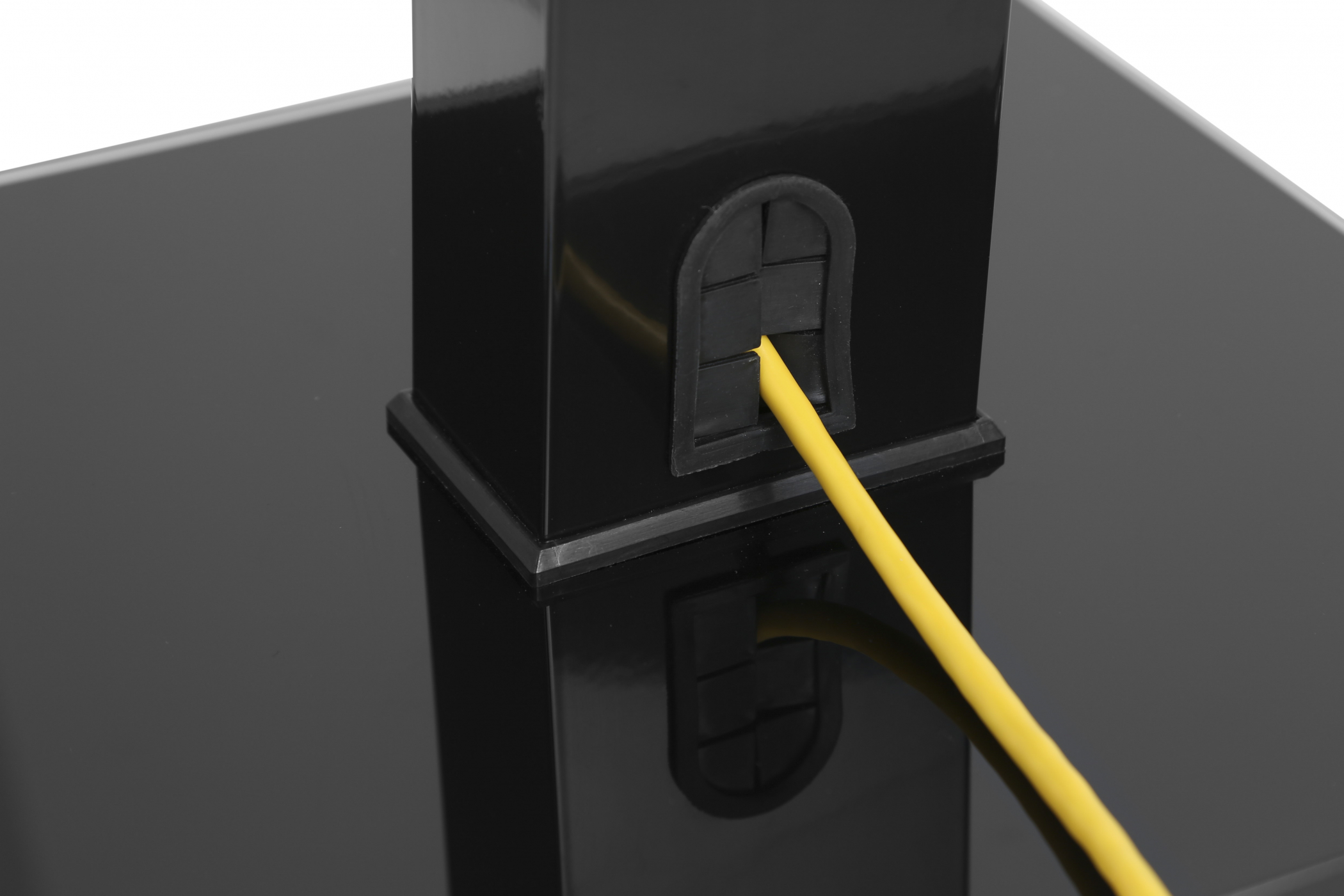 Black stand with a yellow cable running through it.