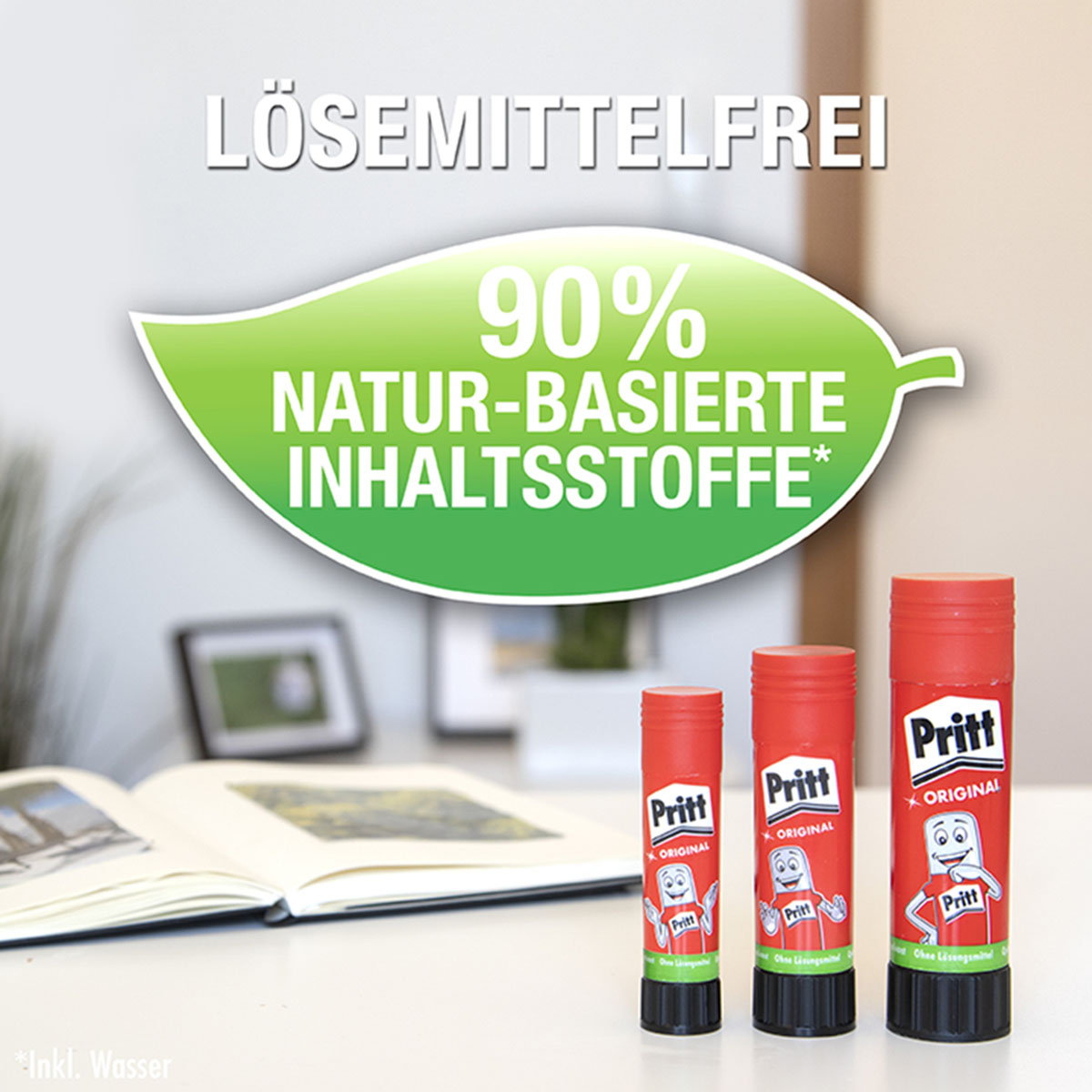 Drei rote Klebestifte der Marke Pritt. Grünes Blatt mit Text auf weißer Oberfläche.