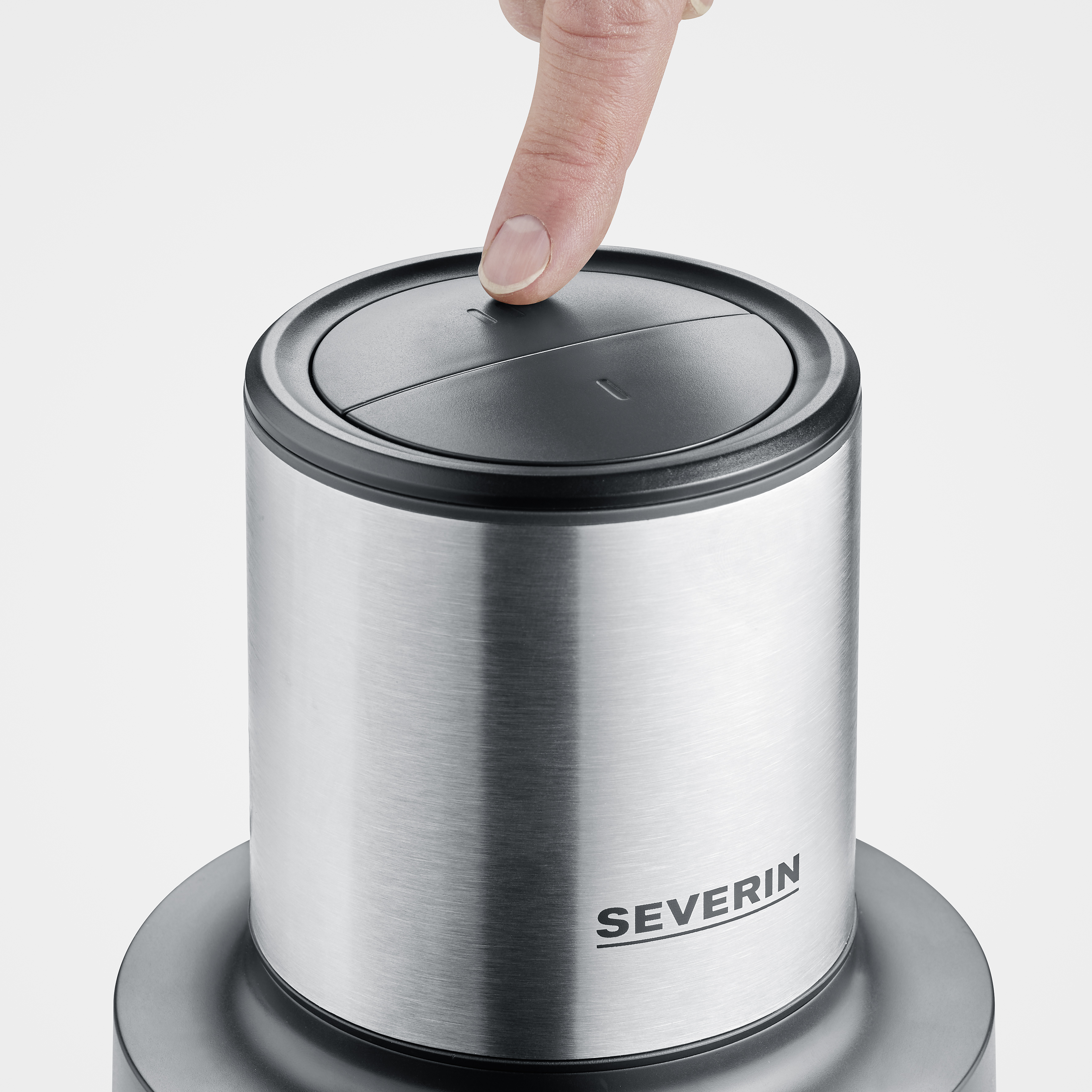 Ein Finger drückt einen Knopf auf einem silbernen und schwarzen Severin-Küchengerät.