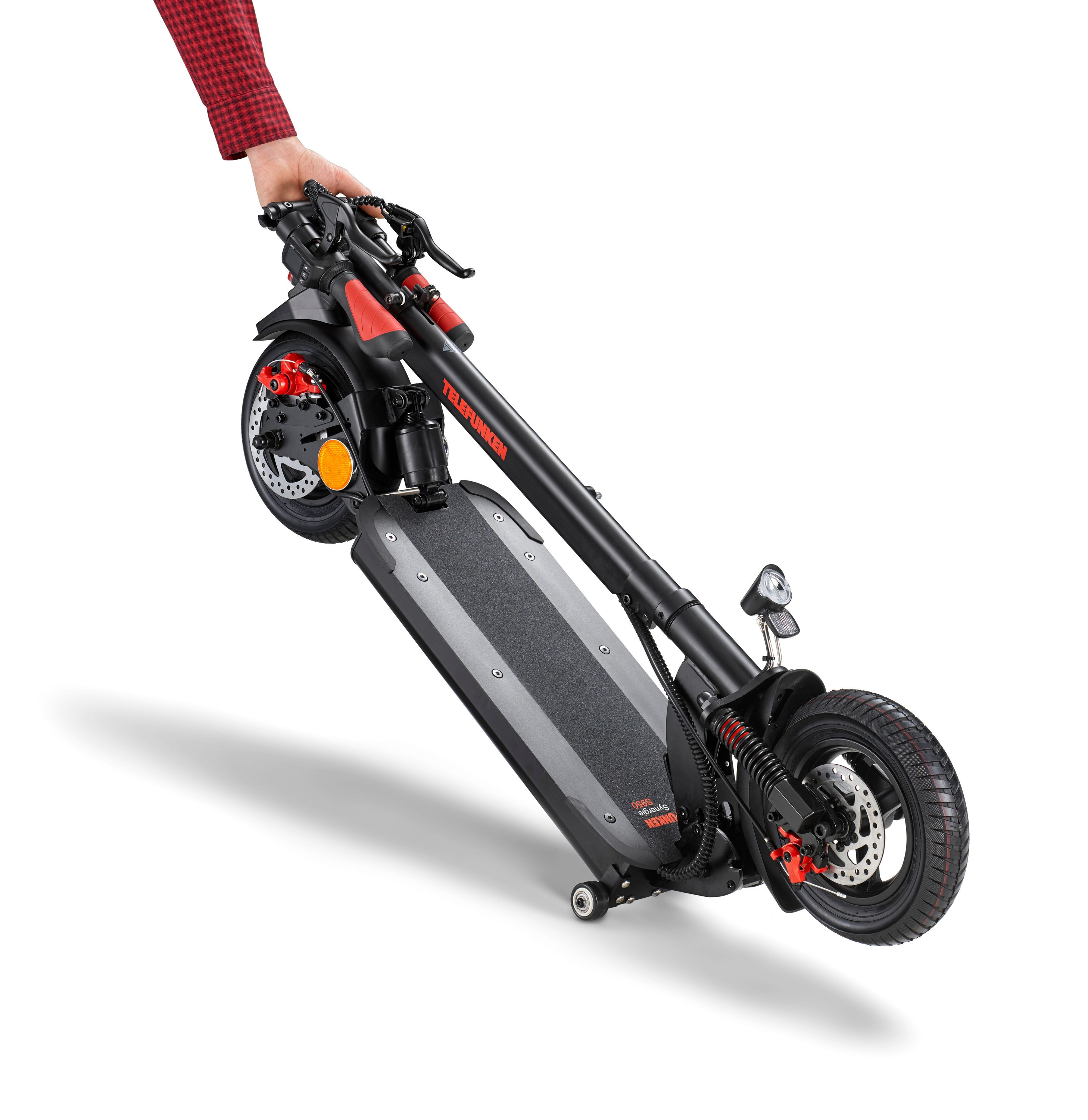 Eine Person hält einen schwarz-roten Elektroroller. Der Roller ist abgewinkelt, seine Räder sind sichtbar.