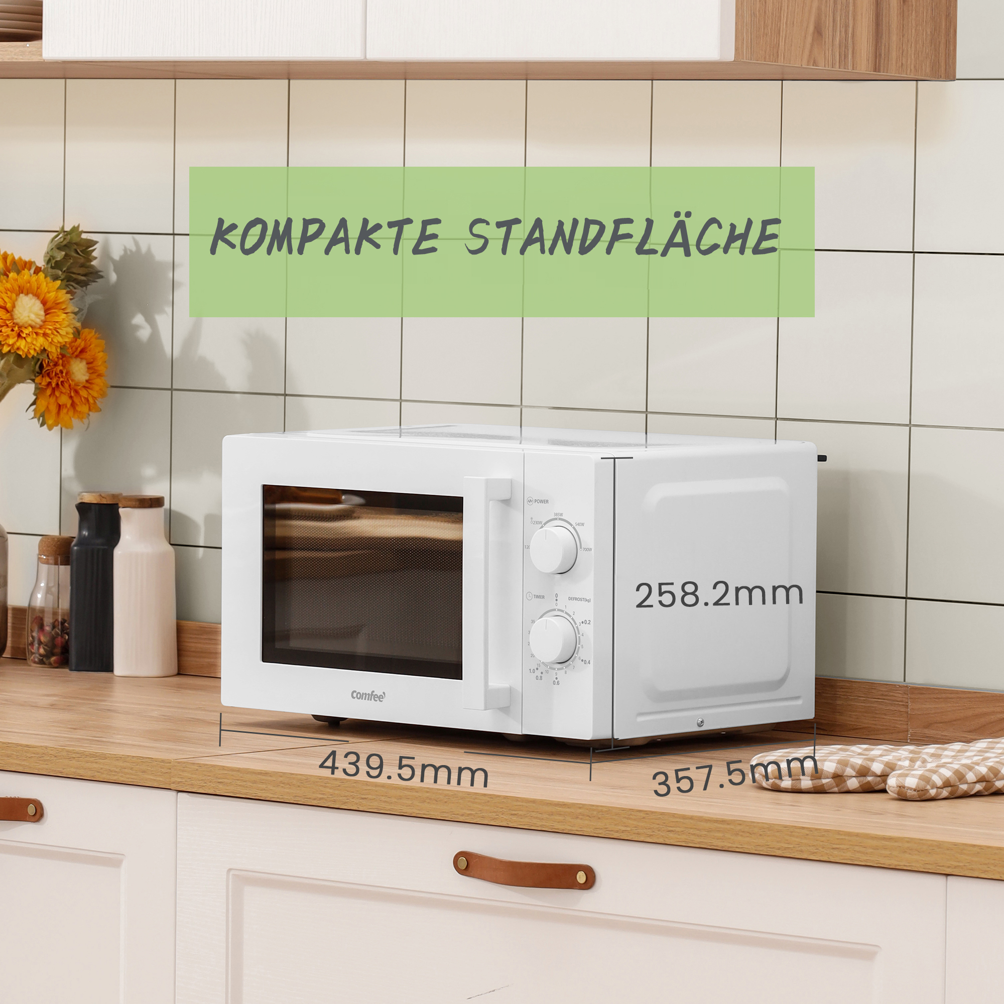 Eine weiße Mikrowelle auf einer Holztheke mit angezeigten Maßen.