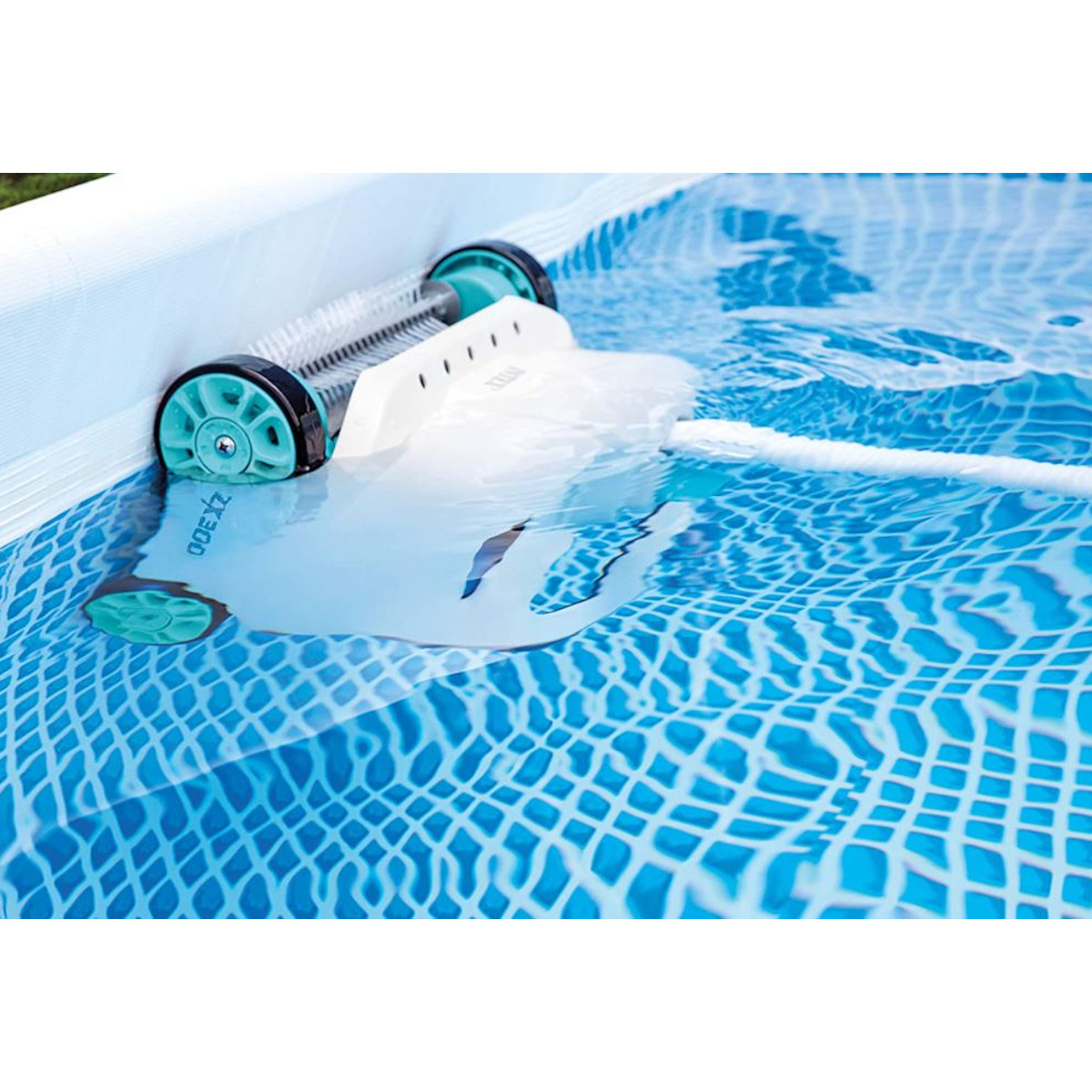 Odkurzacz basenowy w niebieskim basenie z wodą. Odkurzacz jest biały z turkusowymi kołami.