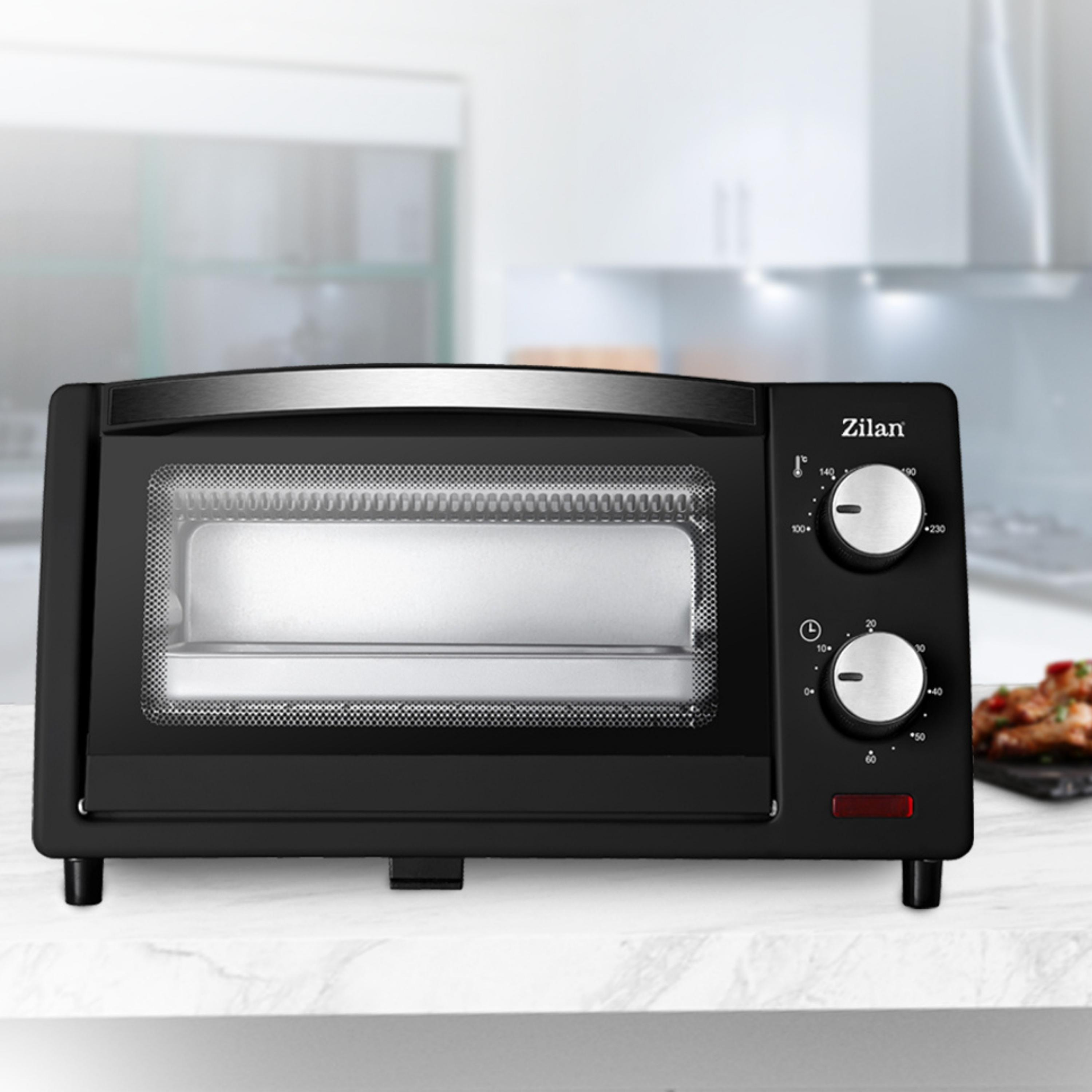 Czarny piekarnik Zilan. Pokrętła i małe czerwone światło po prawej stronie.