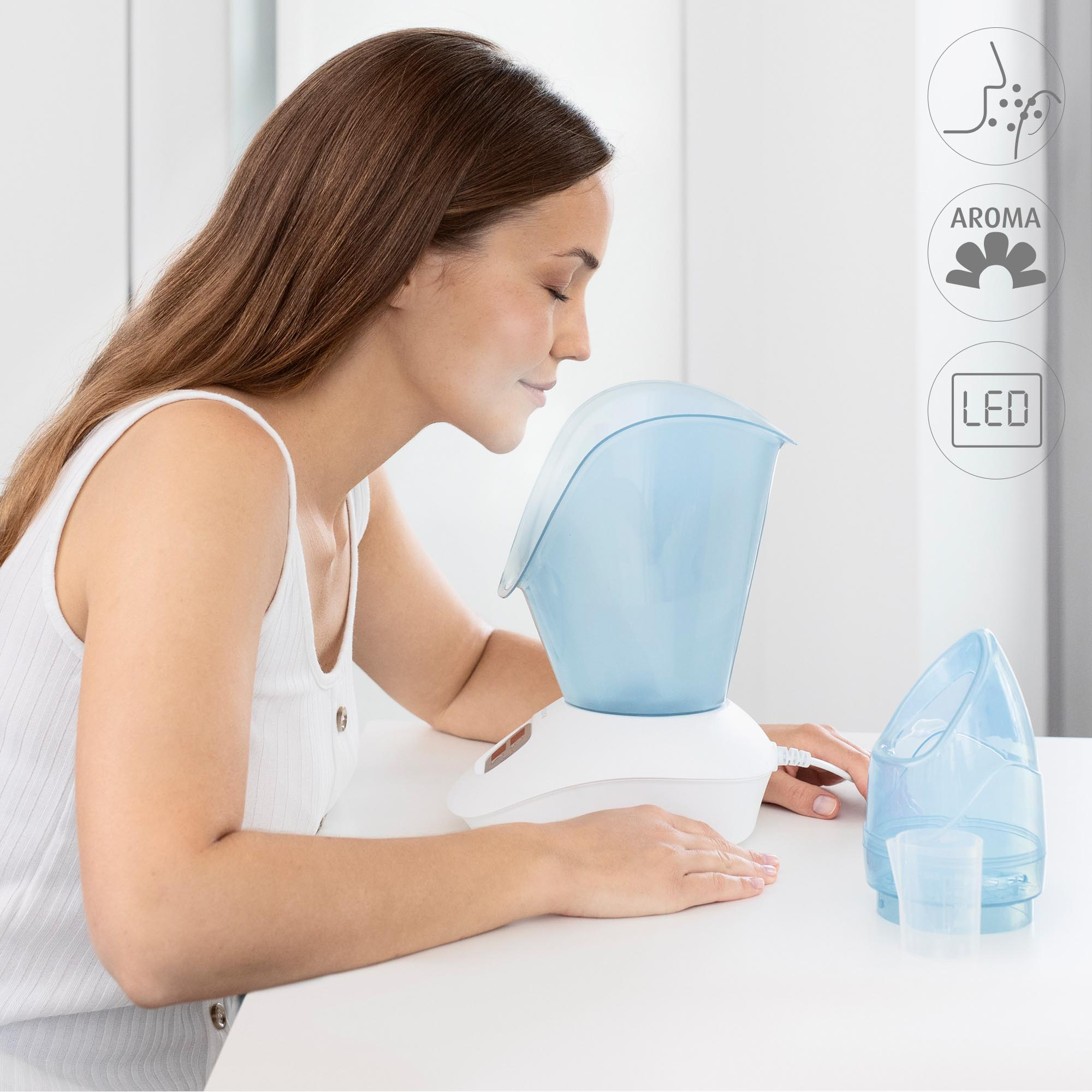 Une femme utilisant un appareil à vapeur pour le visage, avec des icônes d'arôme et de LED à proximité.