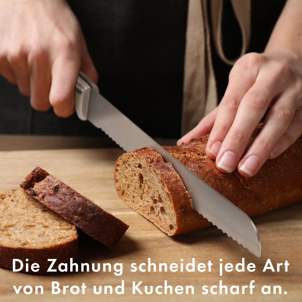 Hände schneiden Brot mit einem gezahnten Messer auf einem Holzbrett, mit zwei Brotscheiben.