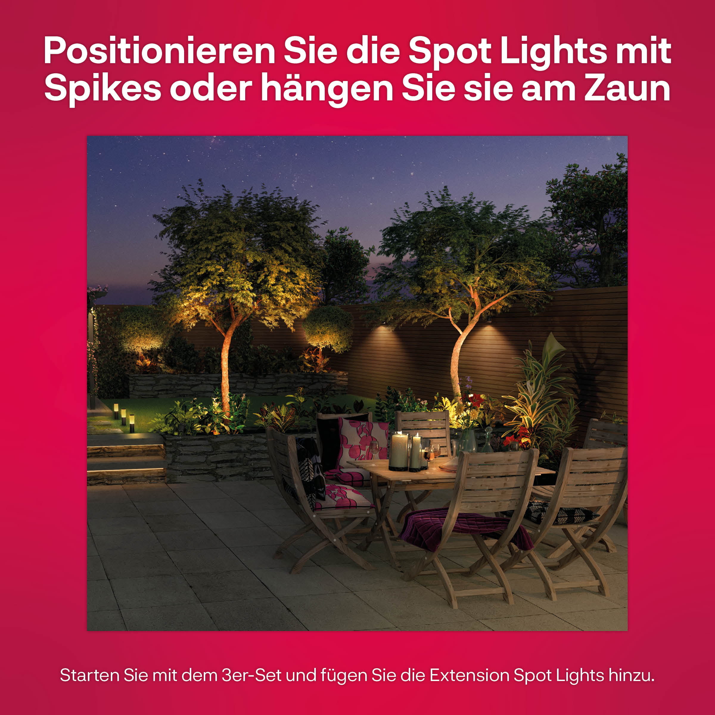 Outdoor scene at night, spot lights on trees, table with flowers, and seating.