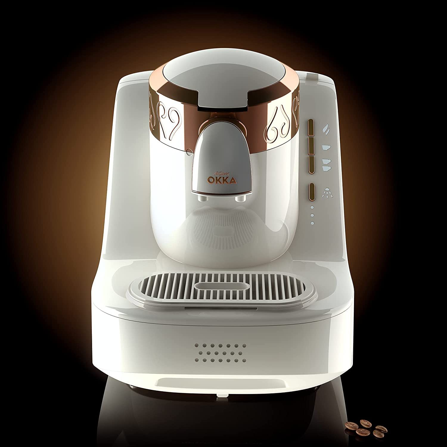 Weiße und goldene Kaffeemaschine mit schwarzem Hintergrund und Kaffeebohnen im Vordergrund.